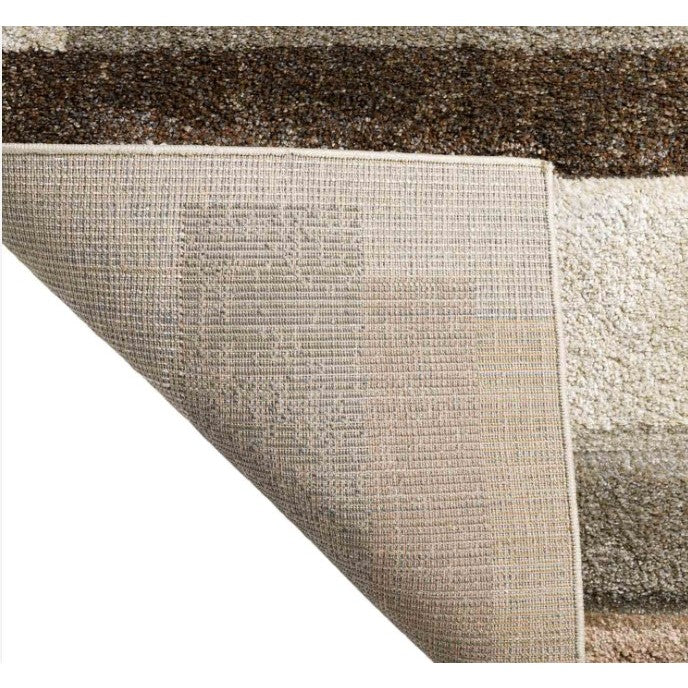 Corner of a multi-toned area rug folded to show back texture and front color detail.