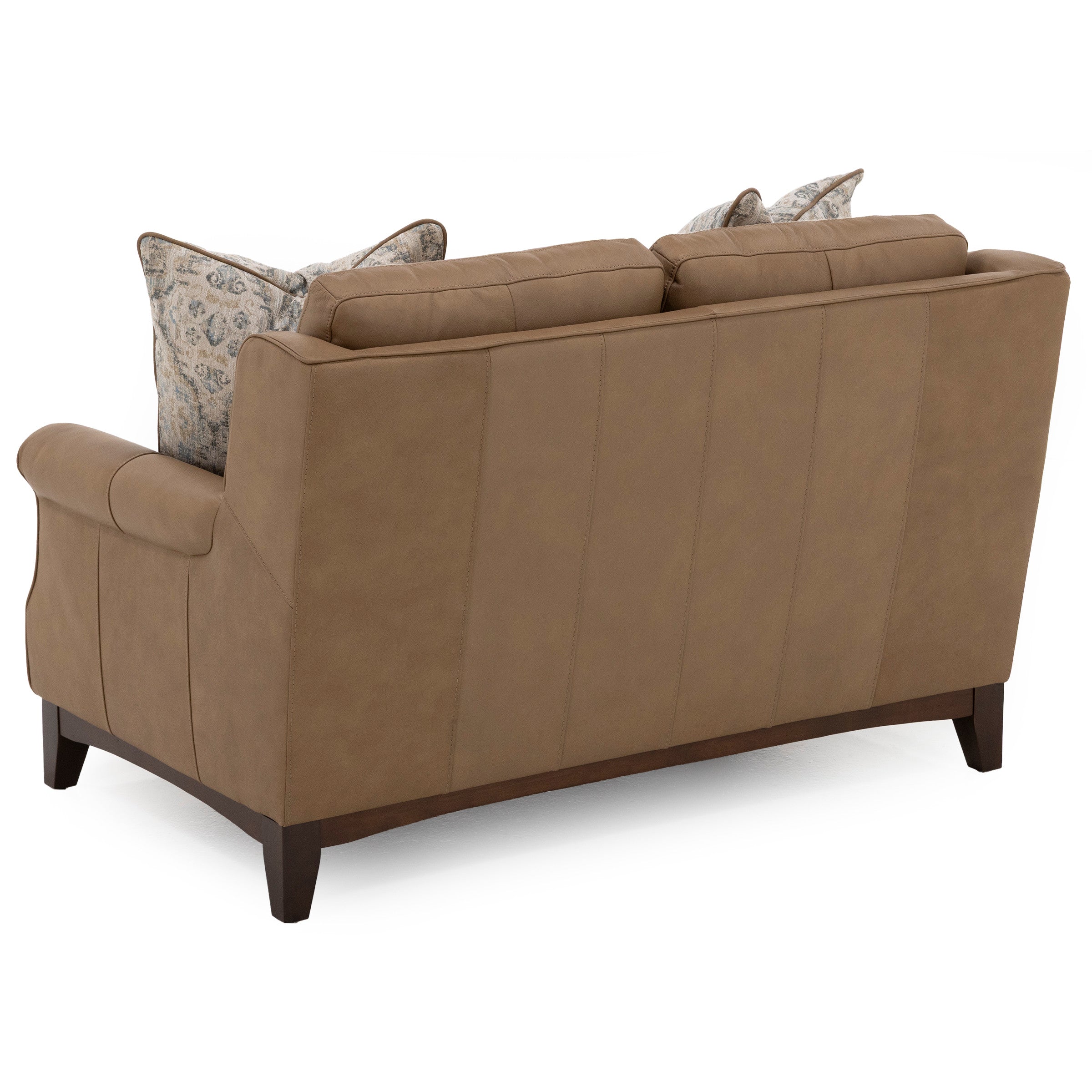 Back view of a tan leather loveseat with patterned pillows.