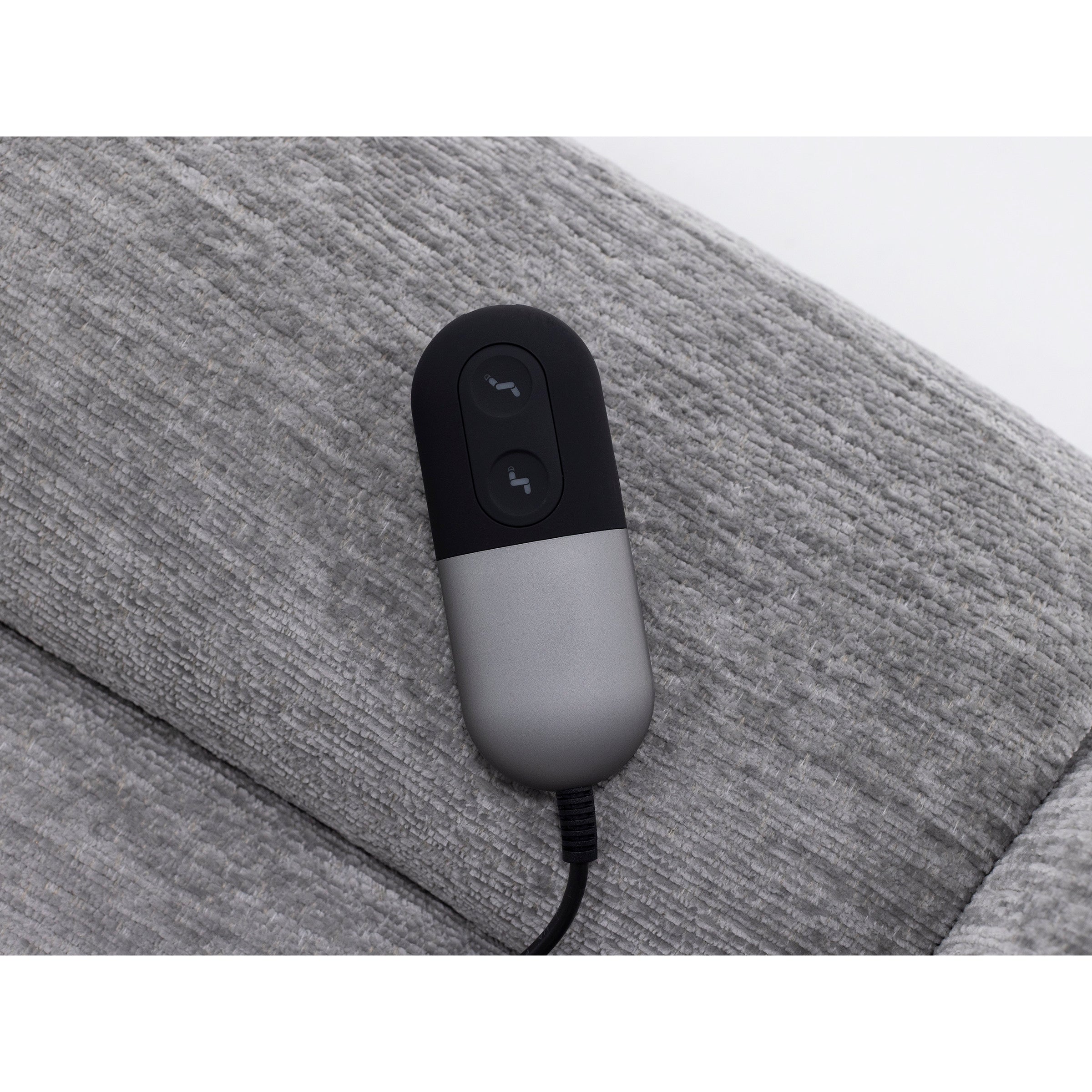 Remote control for adjustable furniture on a gray textured surface.