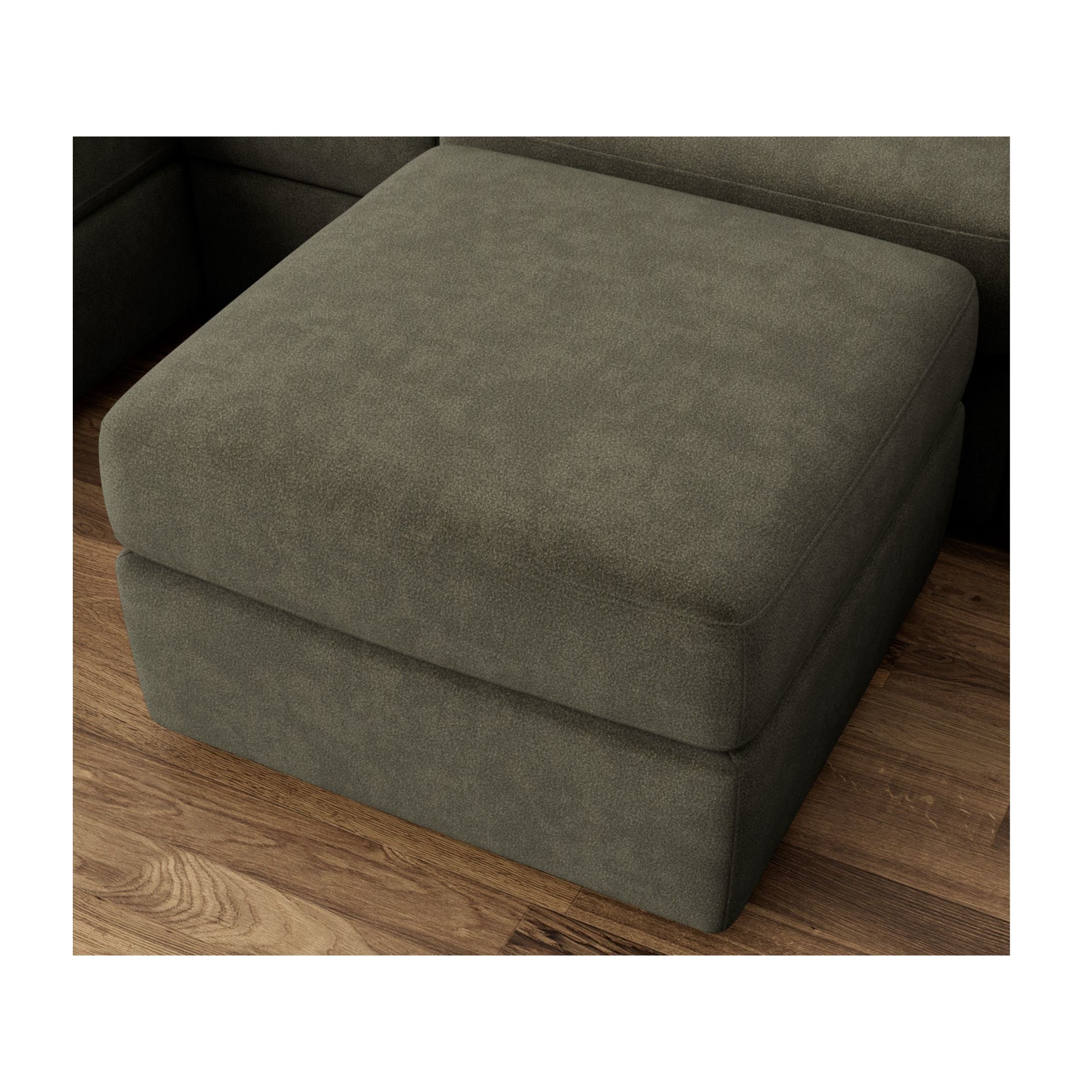 Dark green ottoman on wood floor, part of sectional sofa.