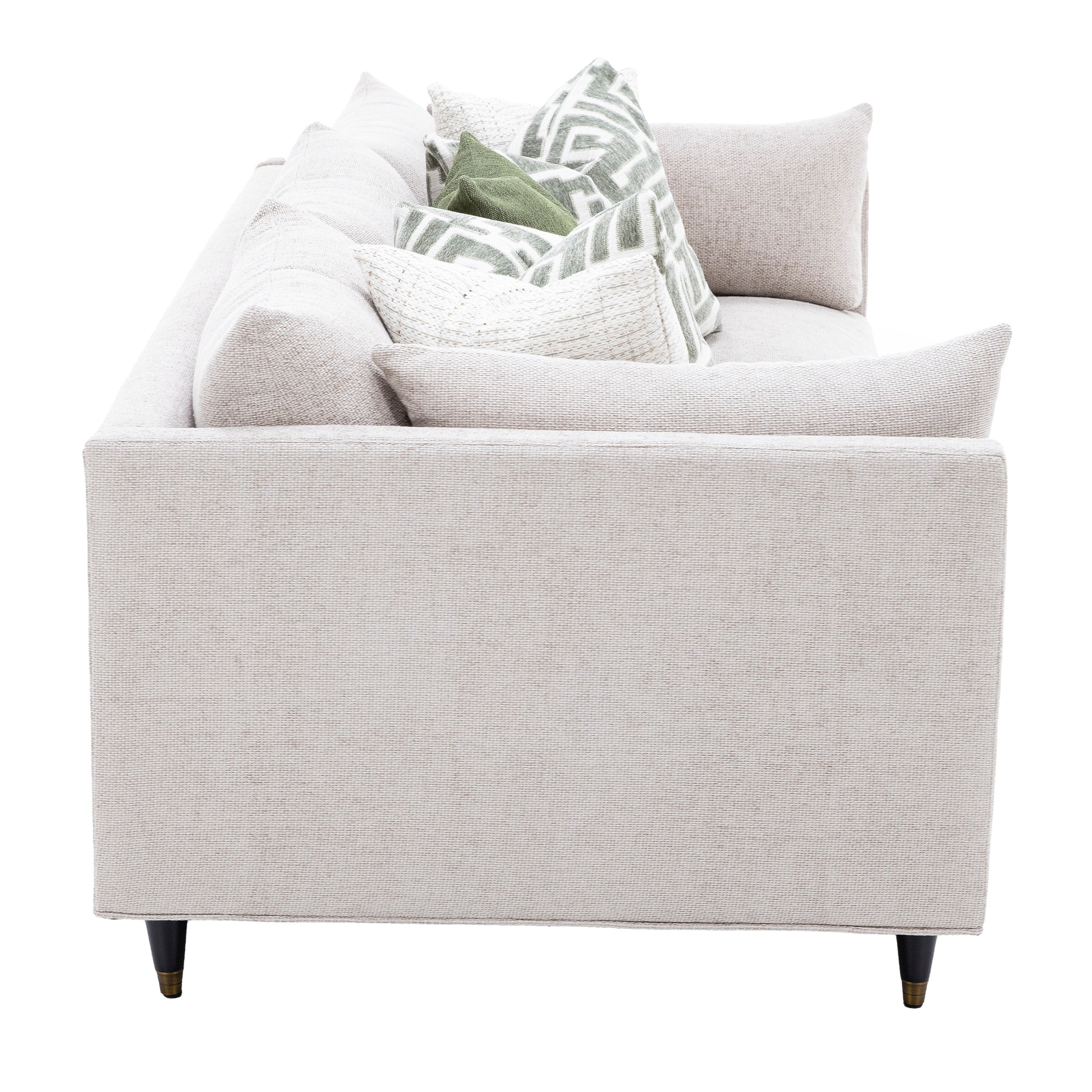 Side view of a light beige sofa with decorative green and patterned throw pillows.
