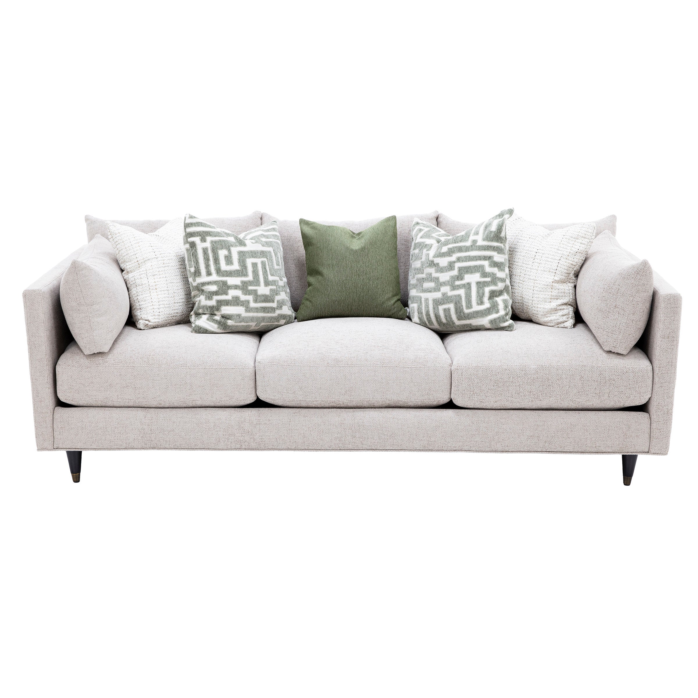 Modern light beige sofa with five decorative pillows in green and white.