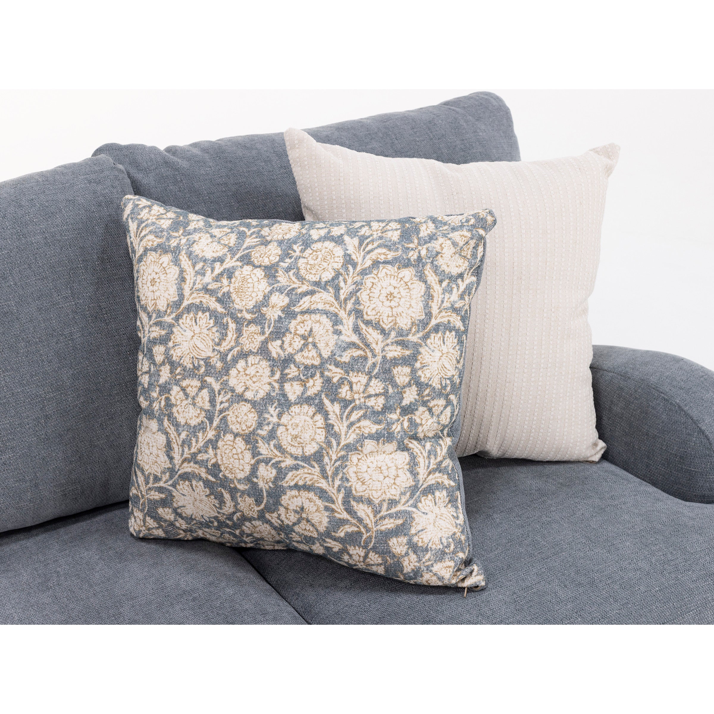 Two decorative throw pillows on a gray fabric sofa.