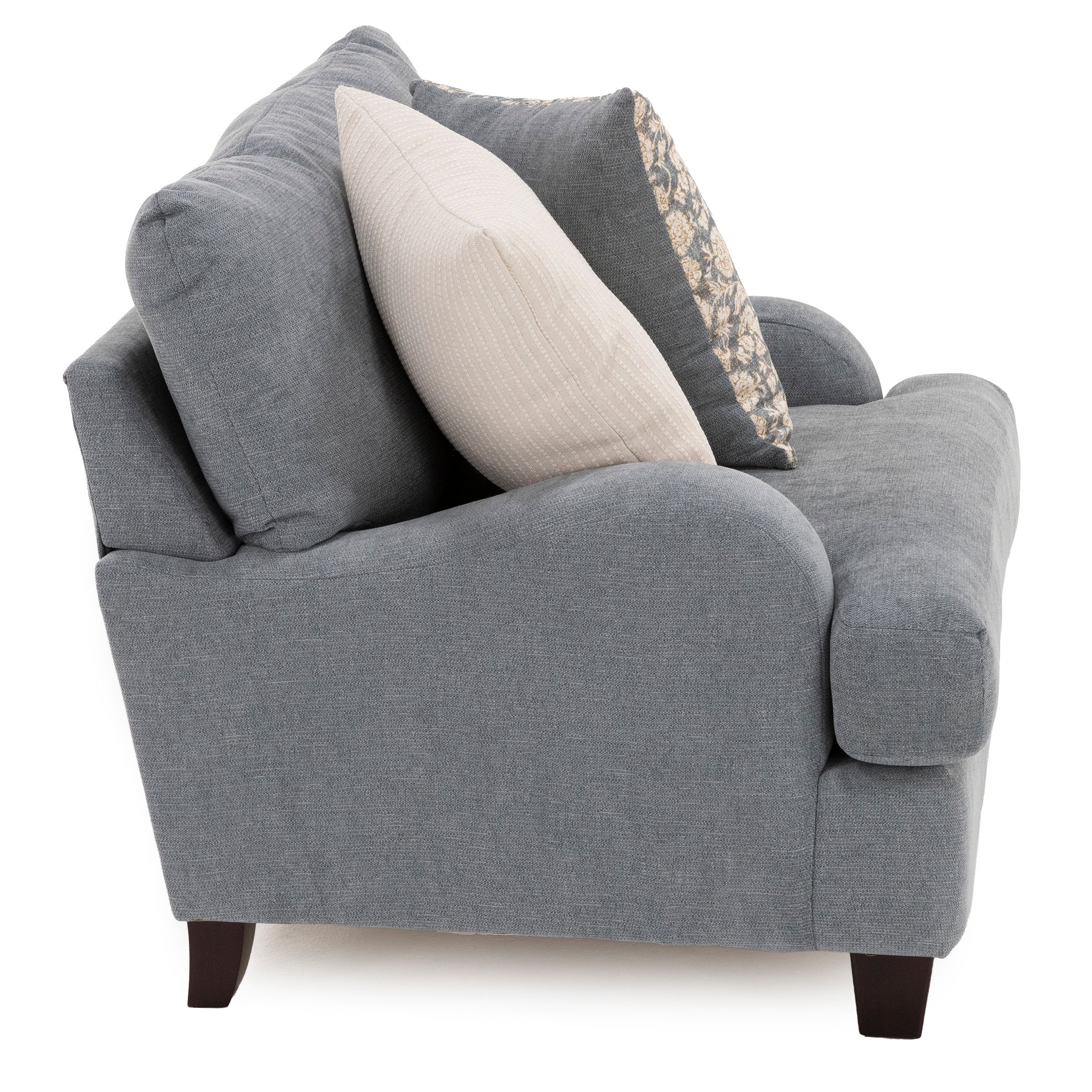 Side view of a gray upholstered armchair with two accent pillows.