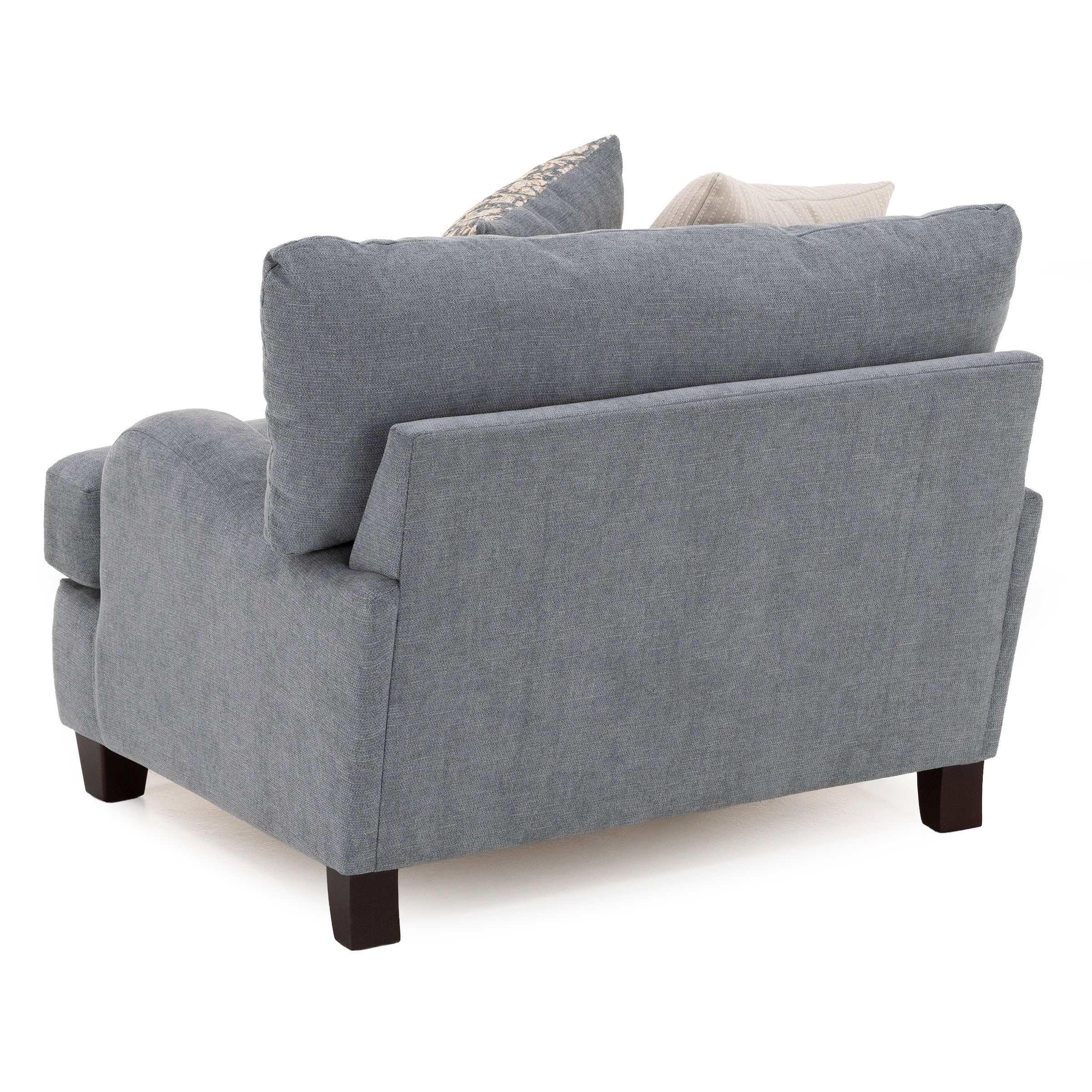 Back angle view of a modern gray upholstered armchair with two accent pillows.
