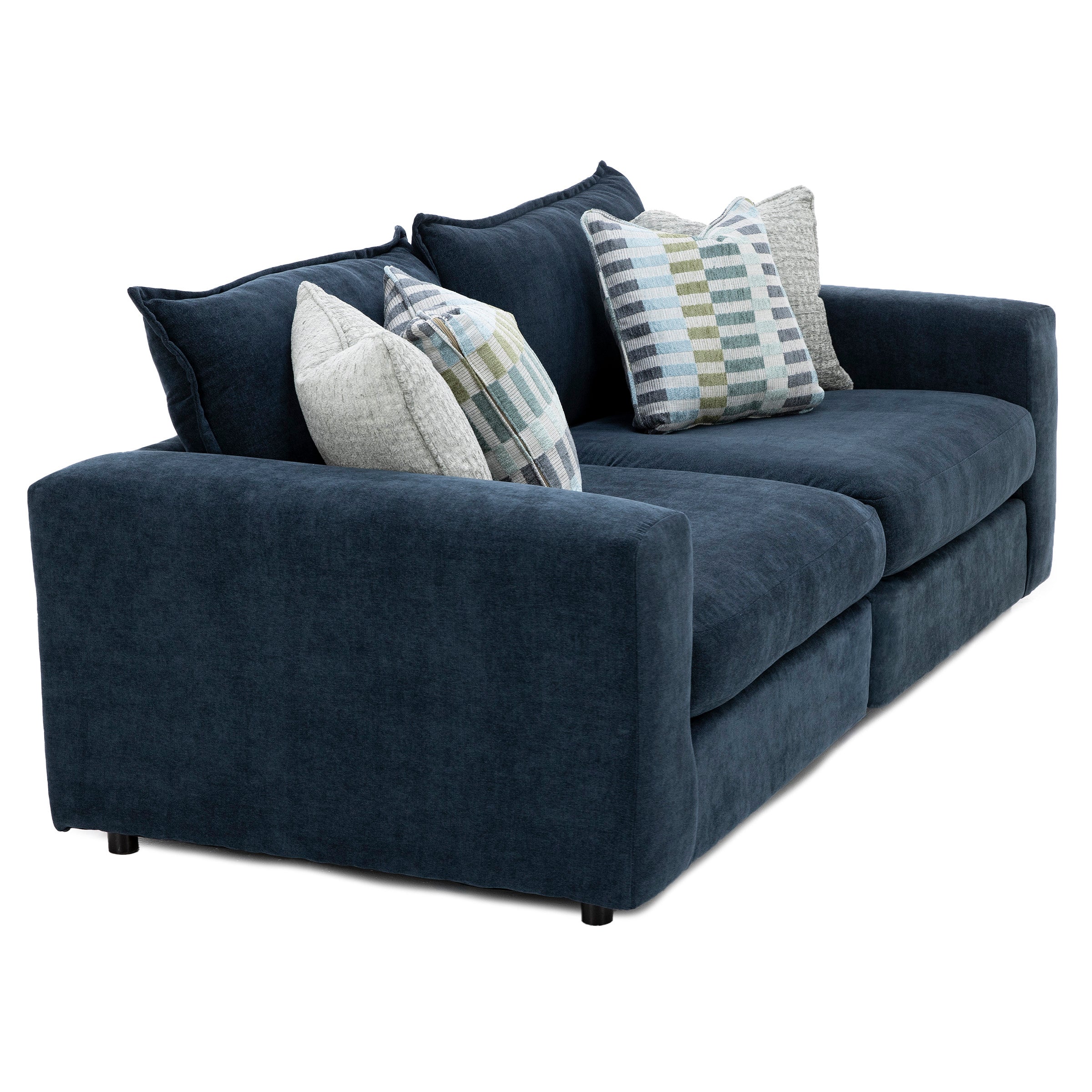 Dark blue sofa with four plush pillows in various neutral and geometric patterns.