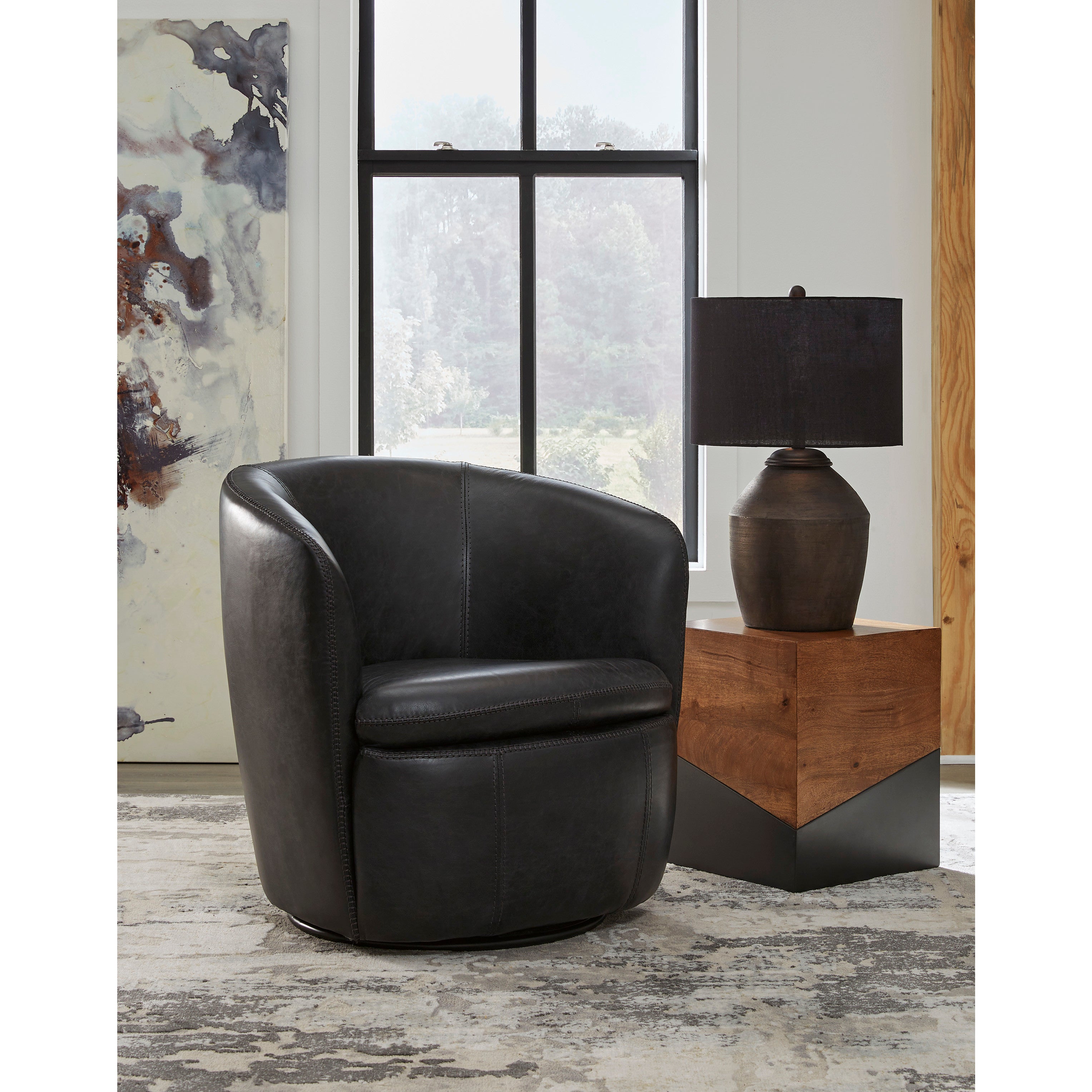 Black leather swivel chair next to a wood side table with lamp in a modern living room.
