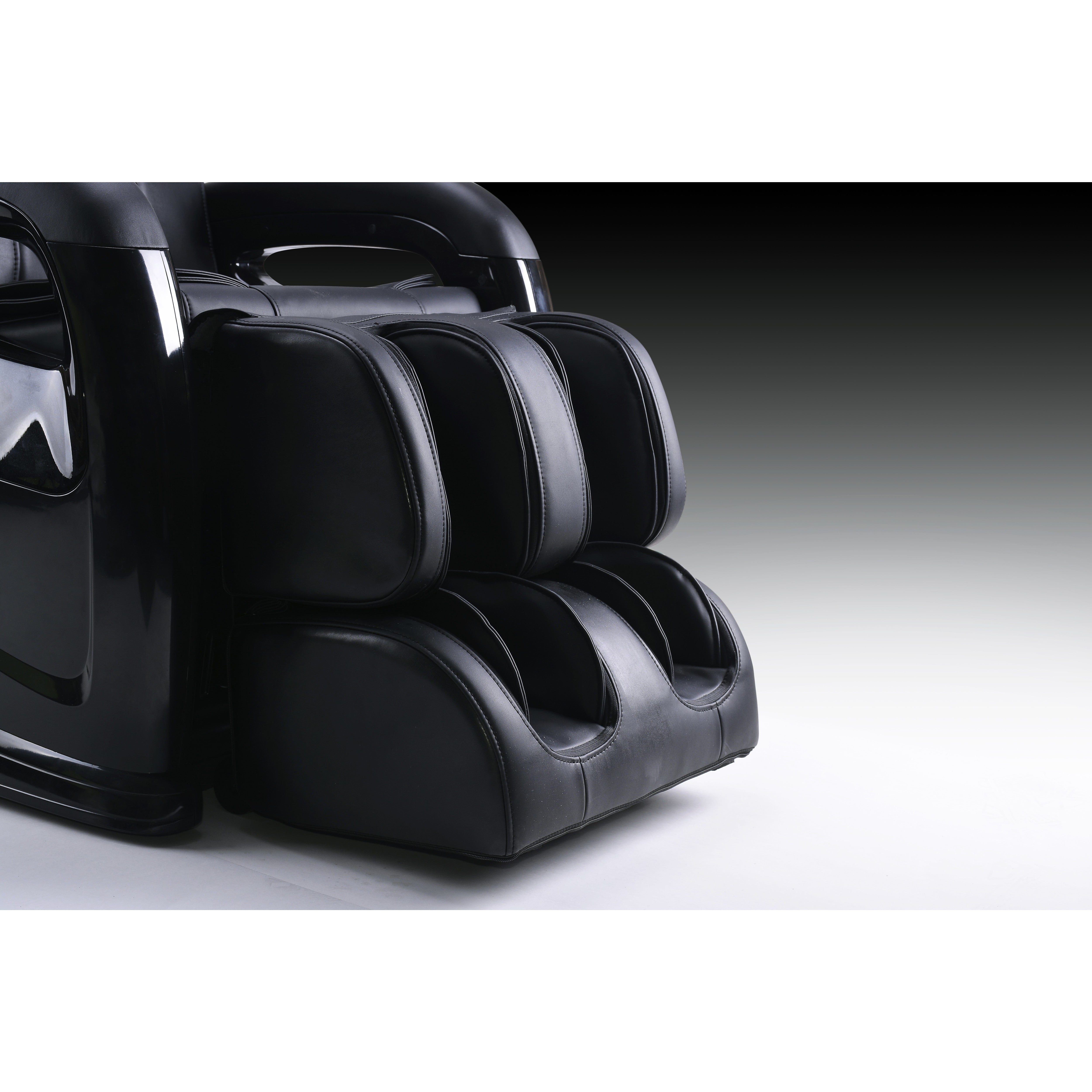 Close-up of a black massage chair footrest with padded calf supports.
