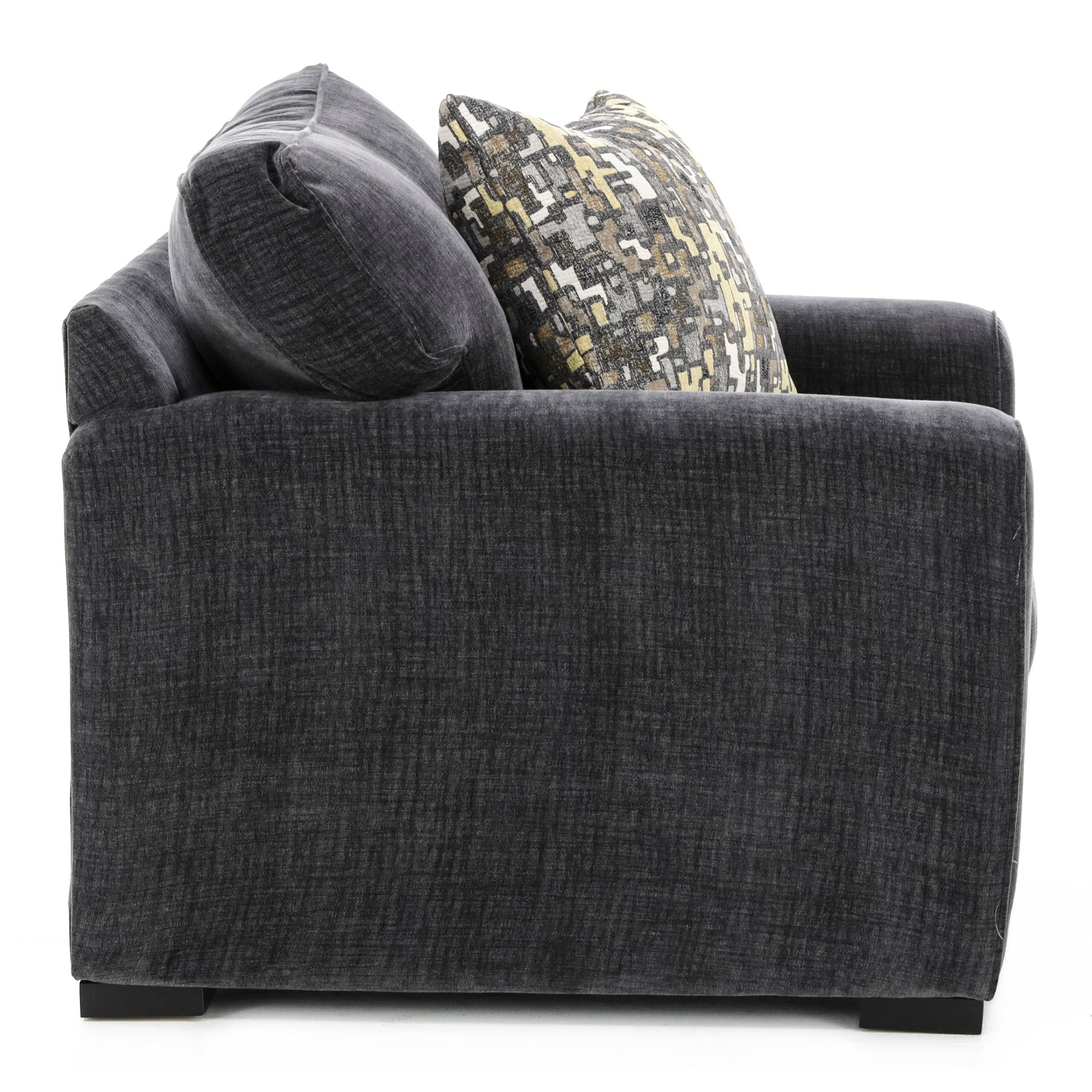 Side view of a dark gray upholstered armchair with patterned accent pillow.
