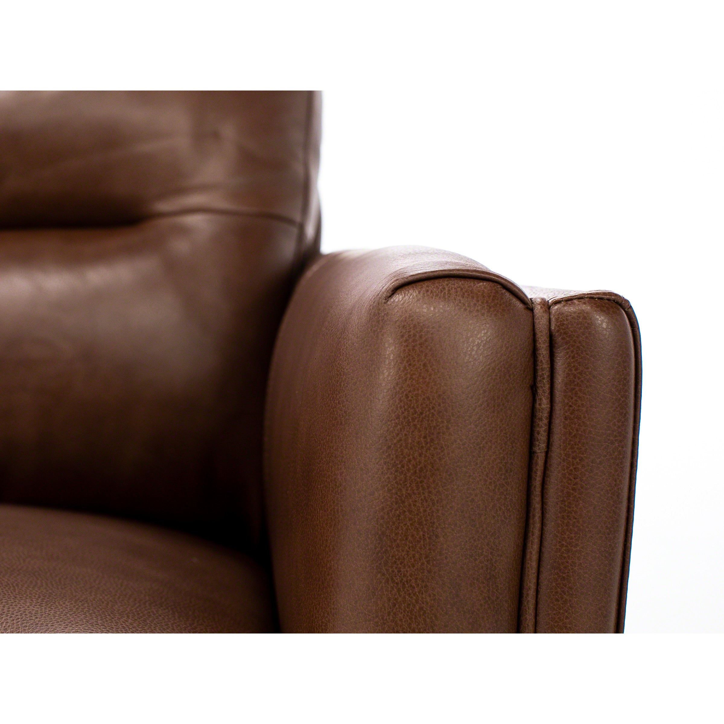 Close-up of a brown leather sofa armrest against a white background.