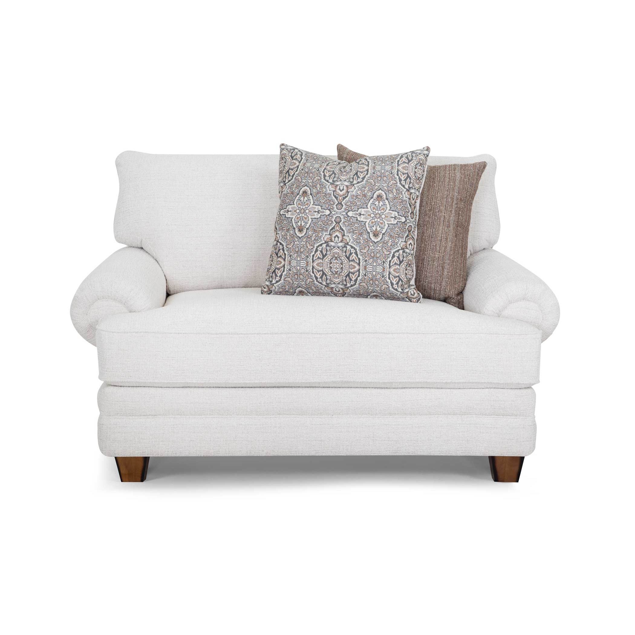 Off-white loveseat with rolled arms and two patterned accent pillows.