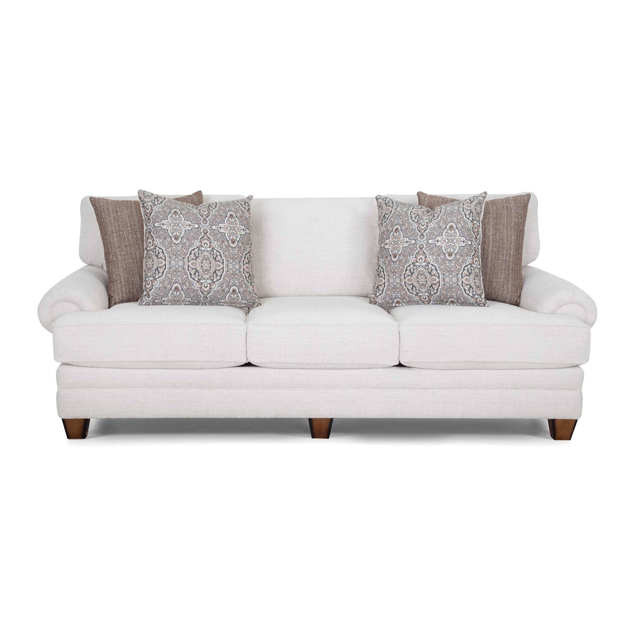 Light beige three-seat sofa with patterned and solid accent pillows.