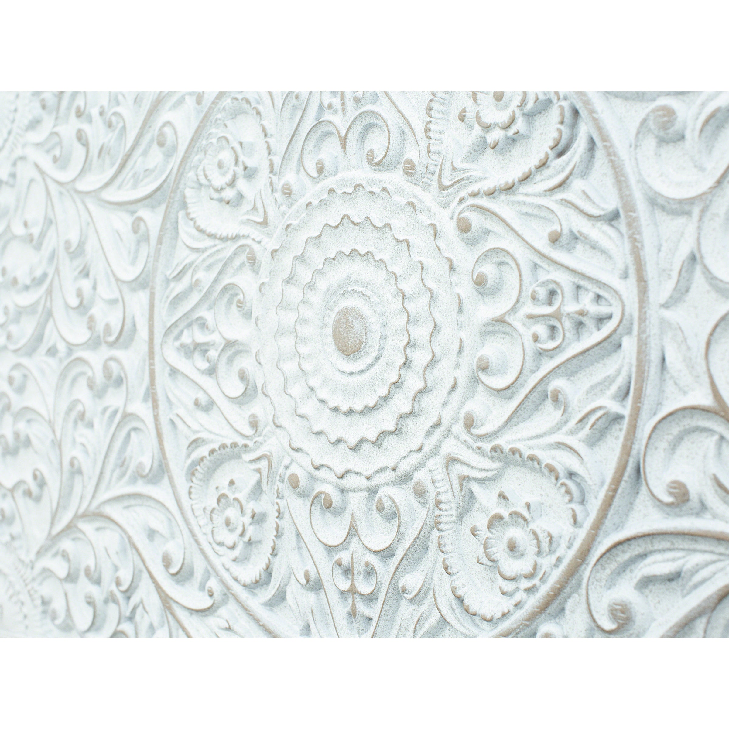 Ornate white carved decorative panel with floral and circular patterns.