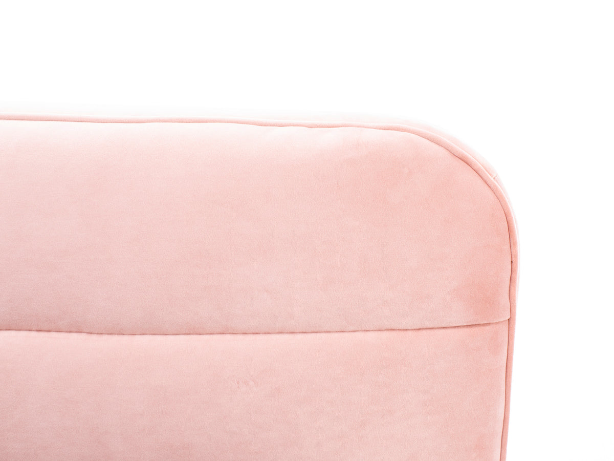 Close-up of a light pink upholstered sofa backrest against a white background.