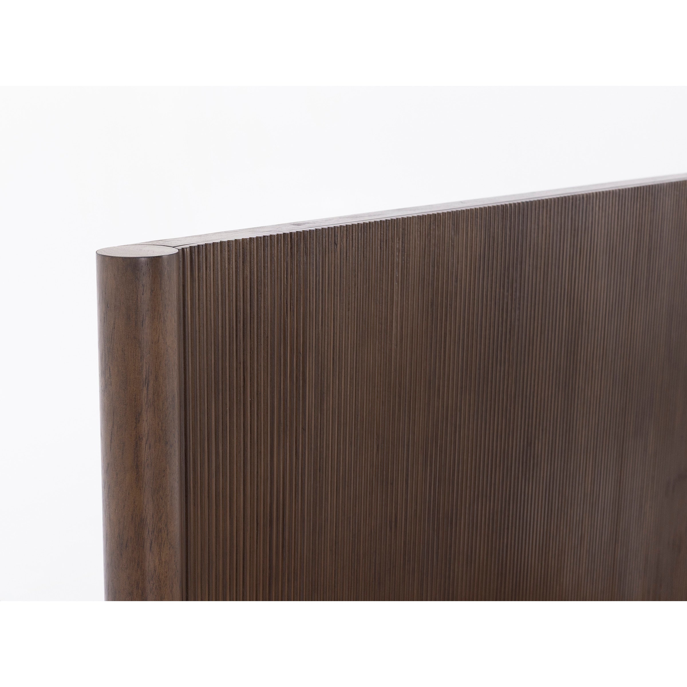 Close-up of a dark wood panel with vertical grooves and a rounded edge.