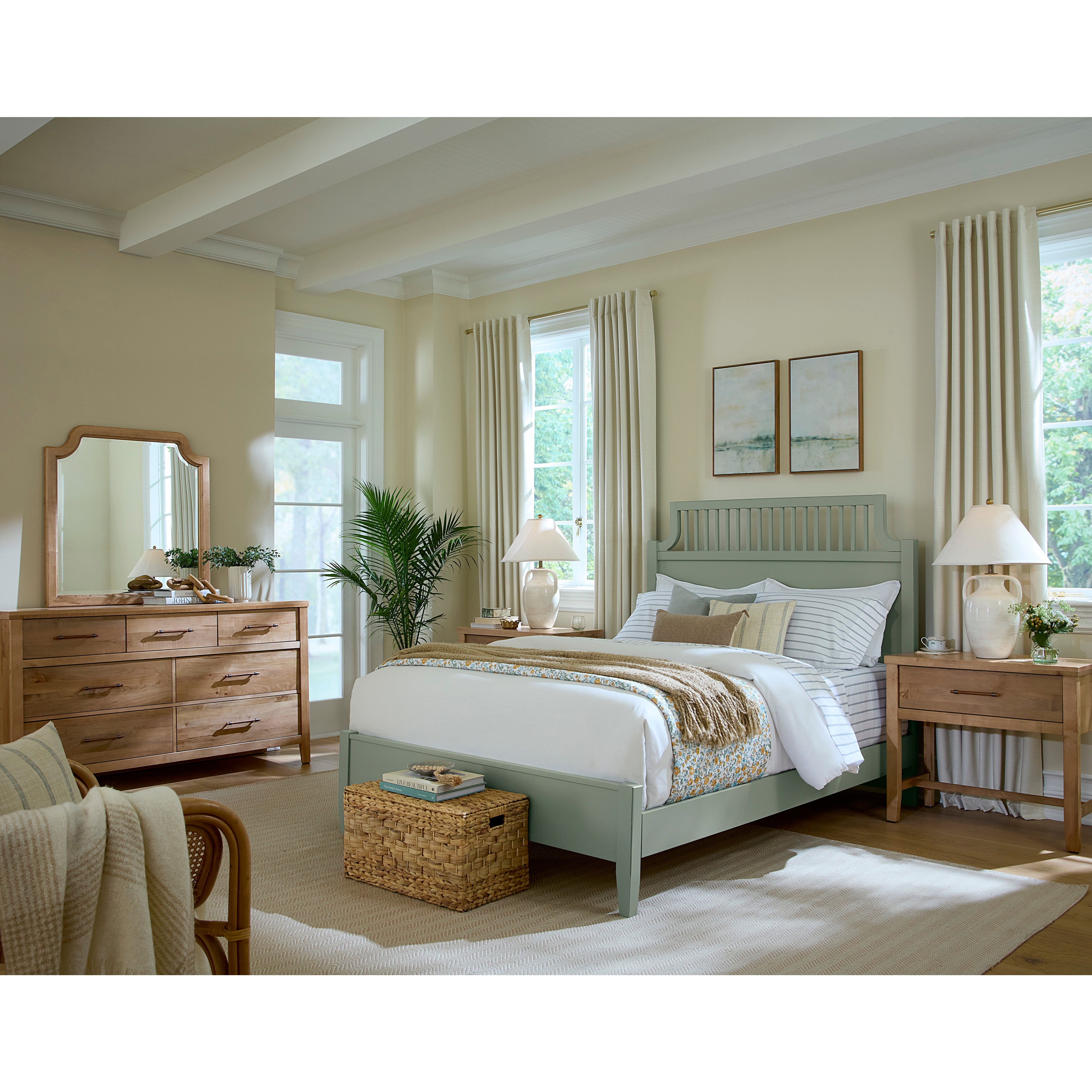 Bright bedroom with a light green bed, wooden furniture, and large windows with cream curtains.