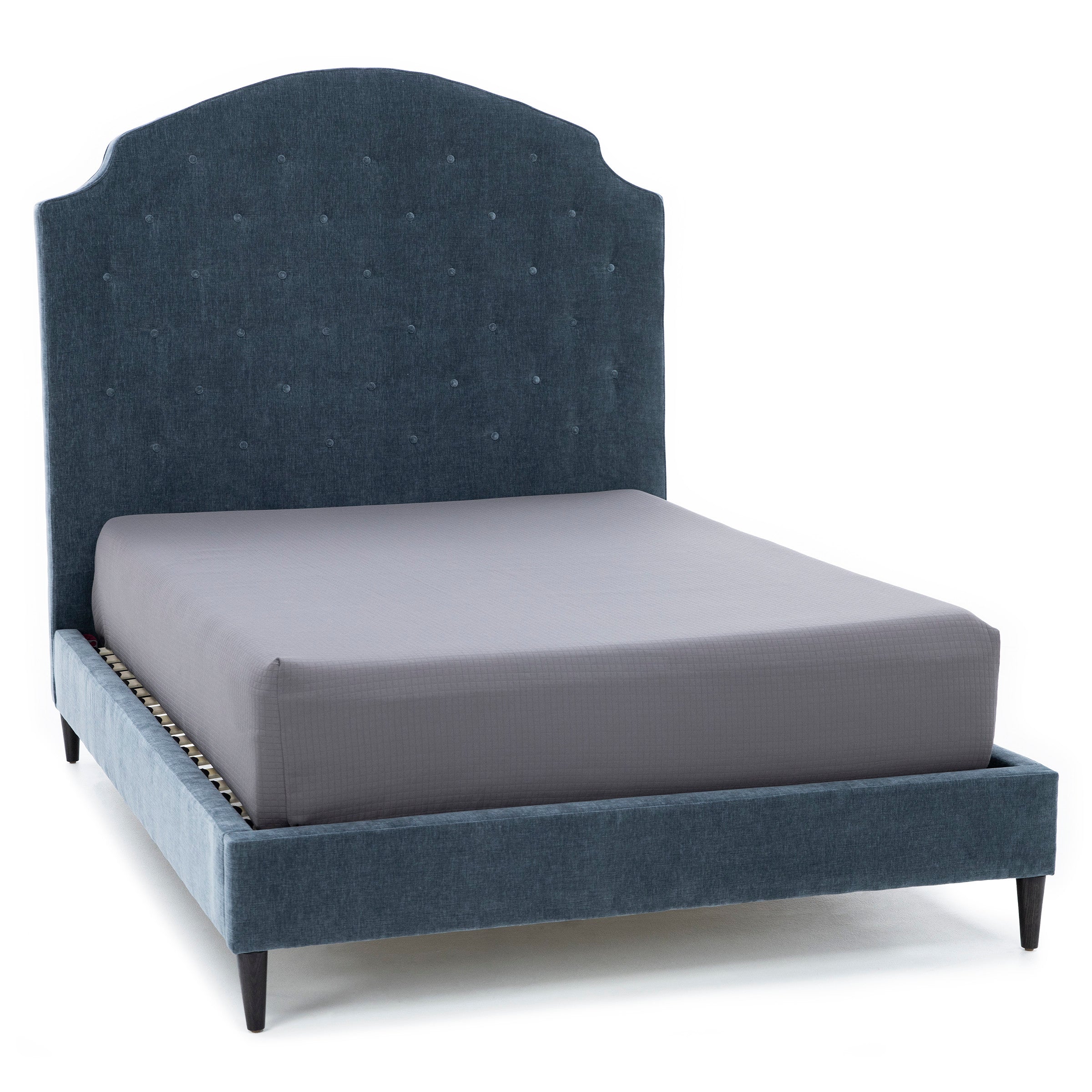 Upholstered bed frame with tall, tufted headboard in blue fabric, shown with mattress.