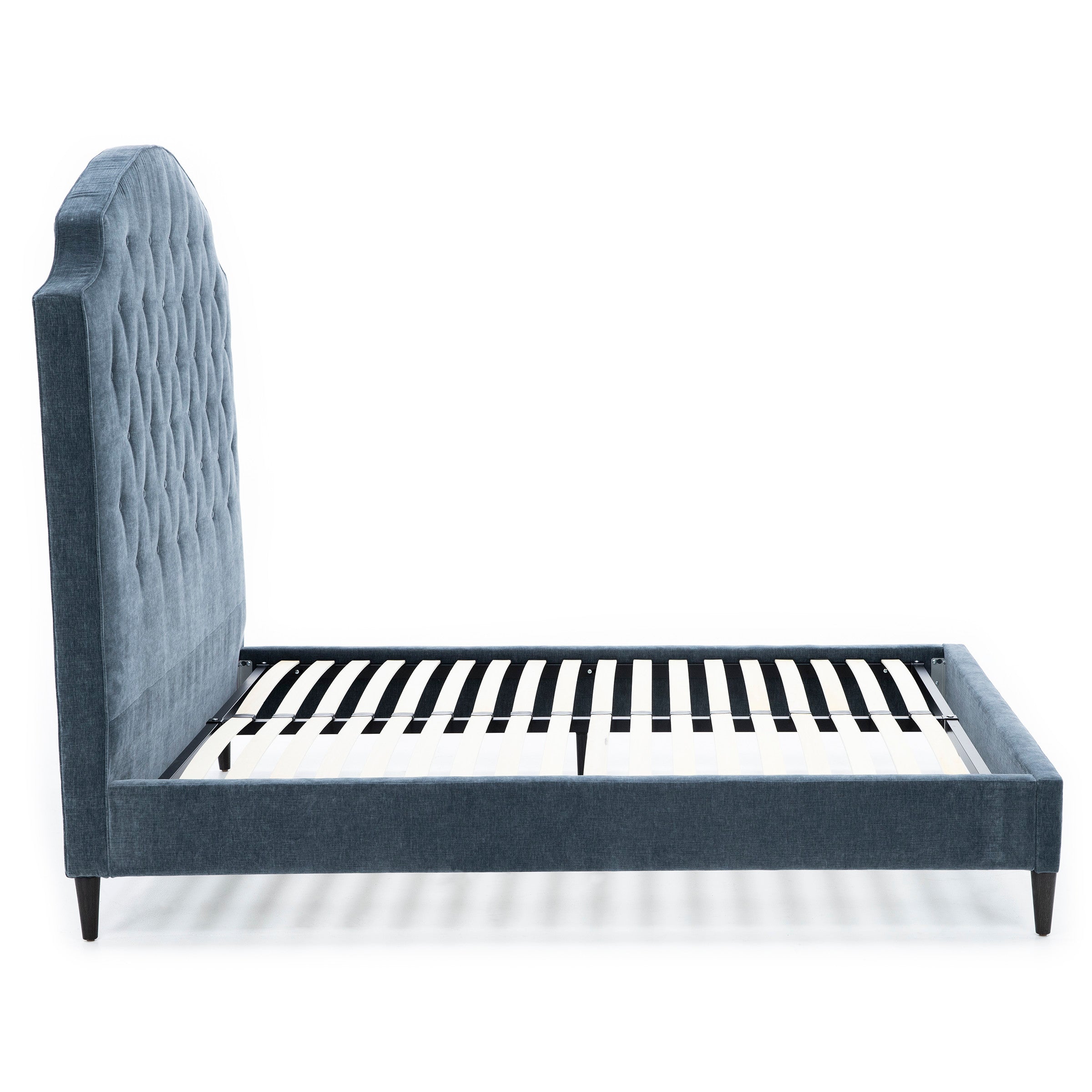 Upholstered bed frame with tall, tufted headboard and wooden slats, side profile.
