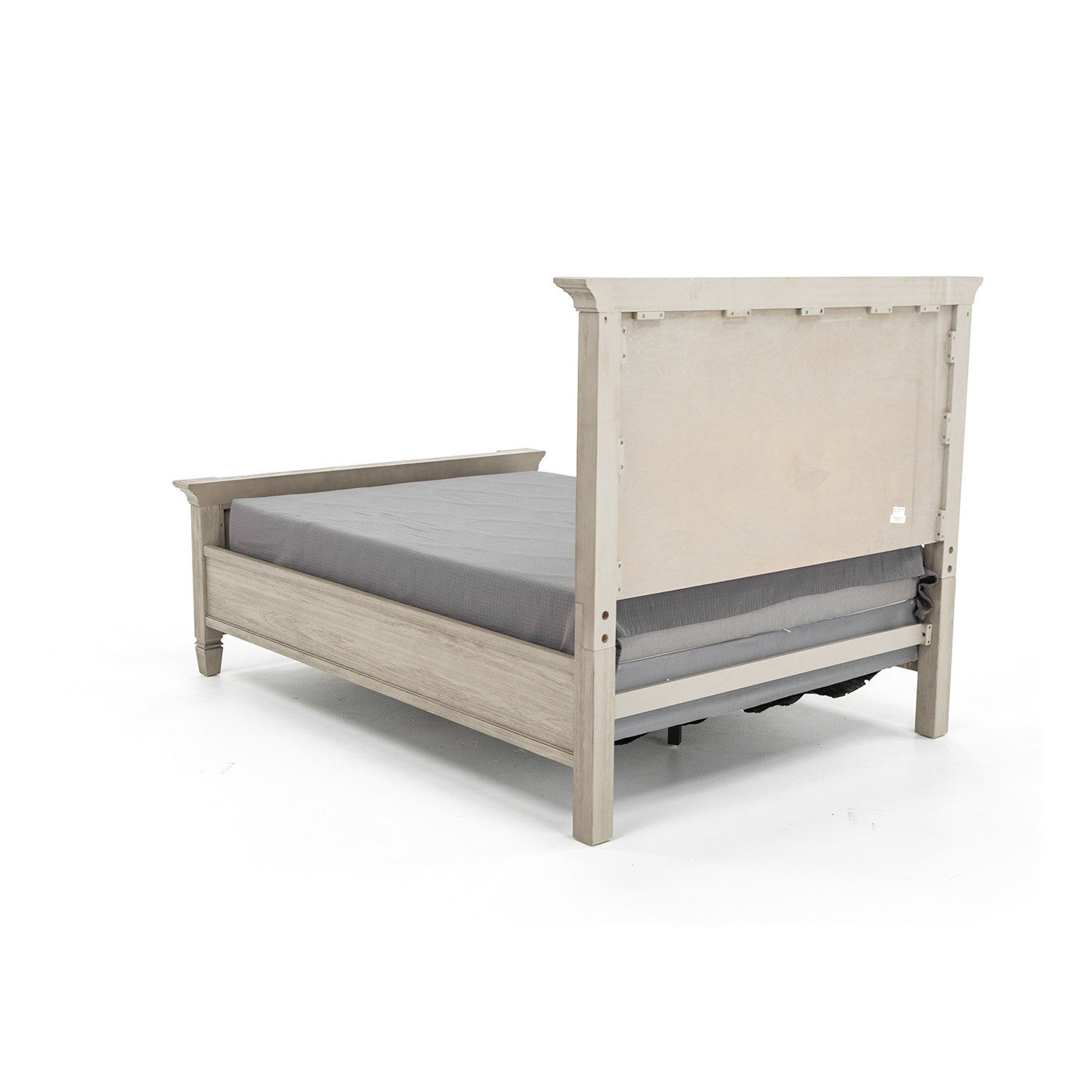Light wood bed frame with raised headboard and grey mattress, shown in a studio setting.