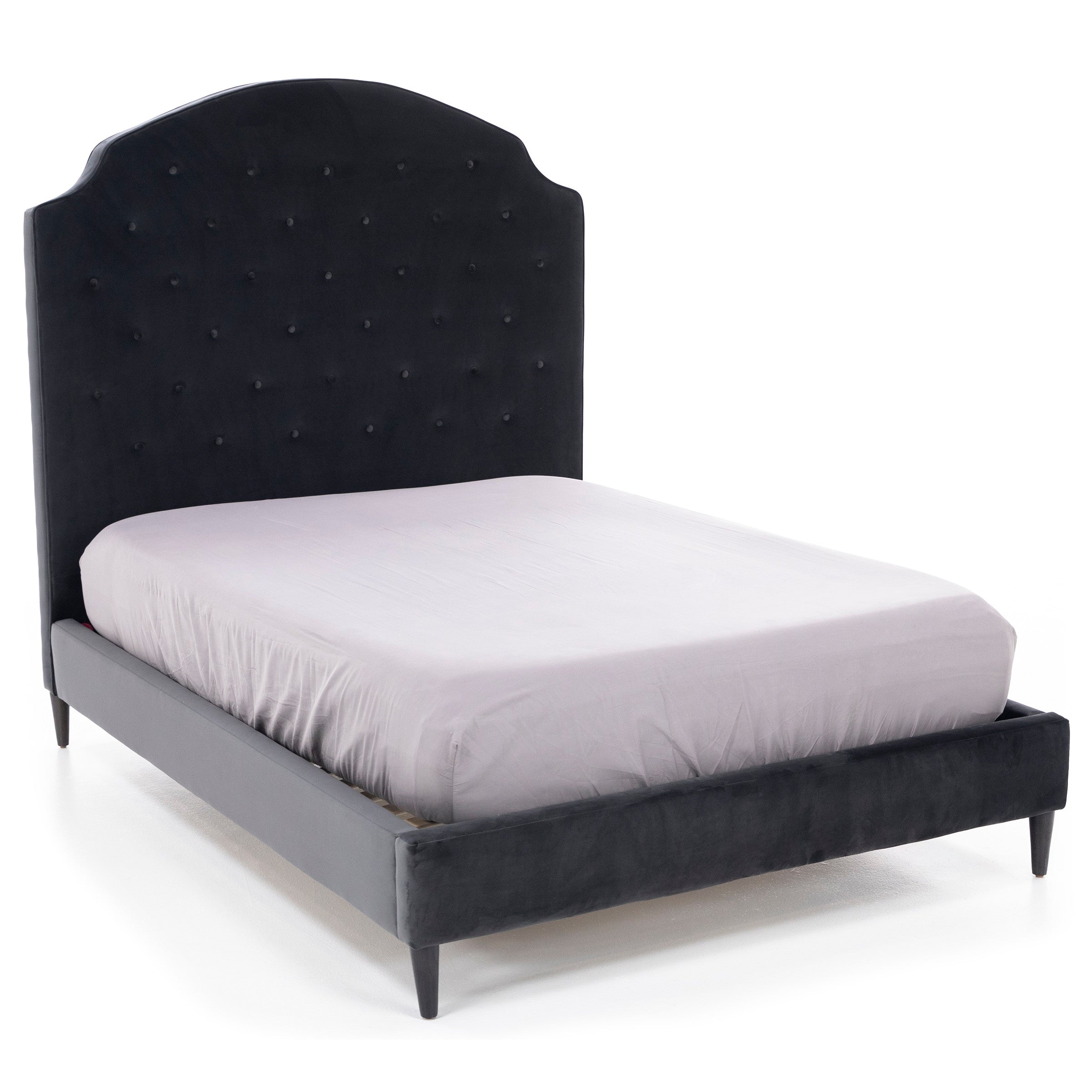 Upholstered bed with a high, tufted headboard in dark fabric.