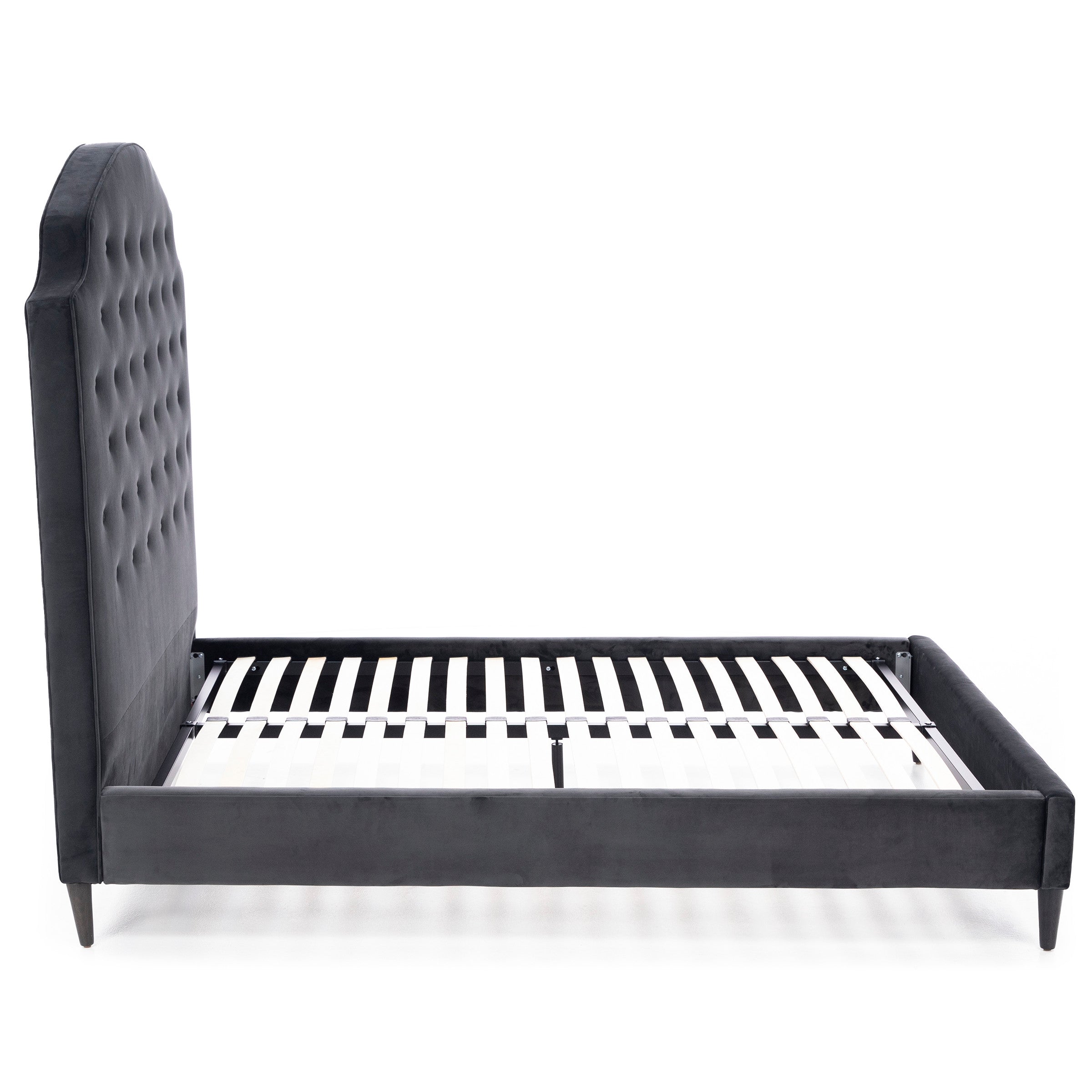 Side view of an upholstered bed frame with a tall tufted headboard.