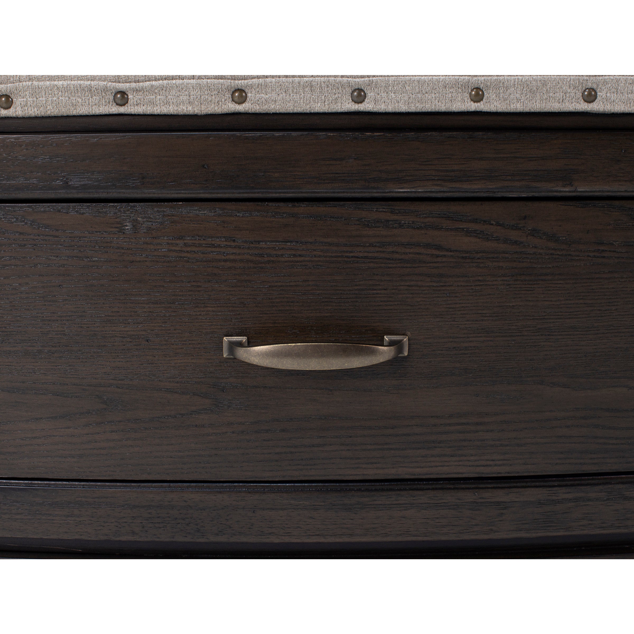 Close-up of a dark wood drawer with a metal handle and upholstered trim.