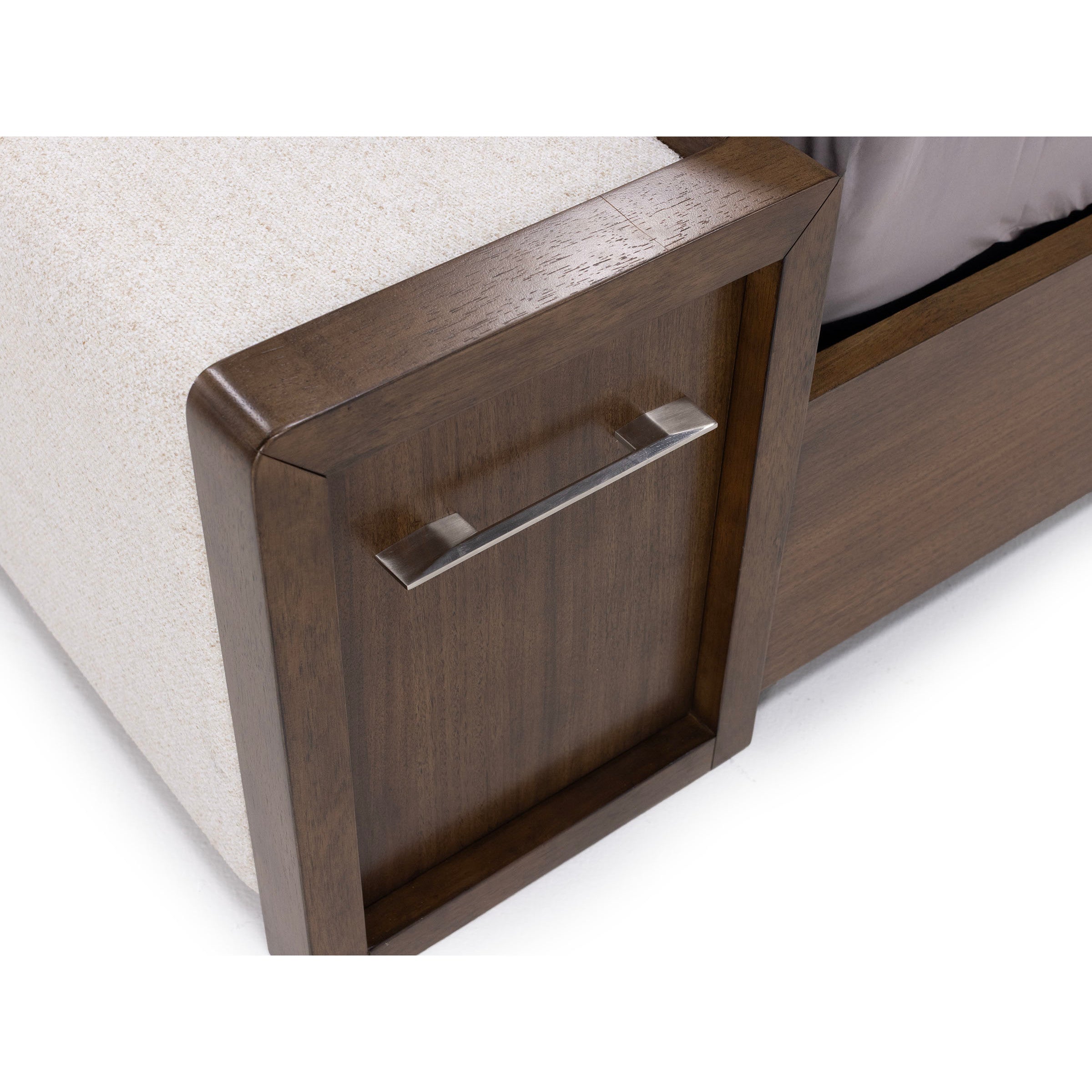 Close-up of a wooden bed with built-in storage drawer and metal handle.