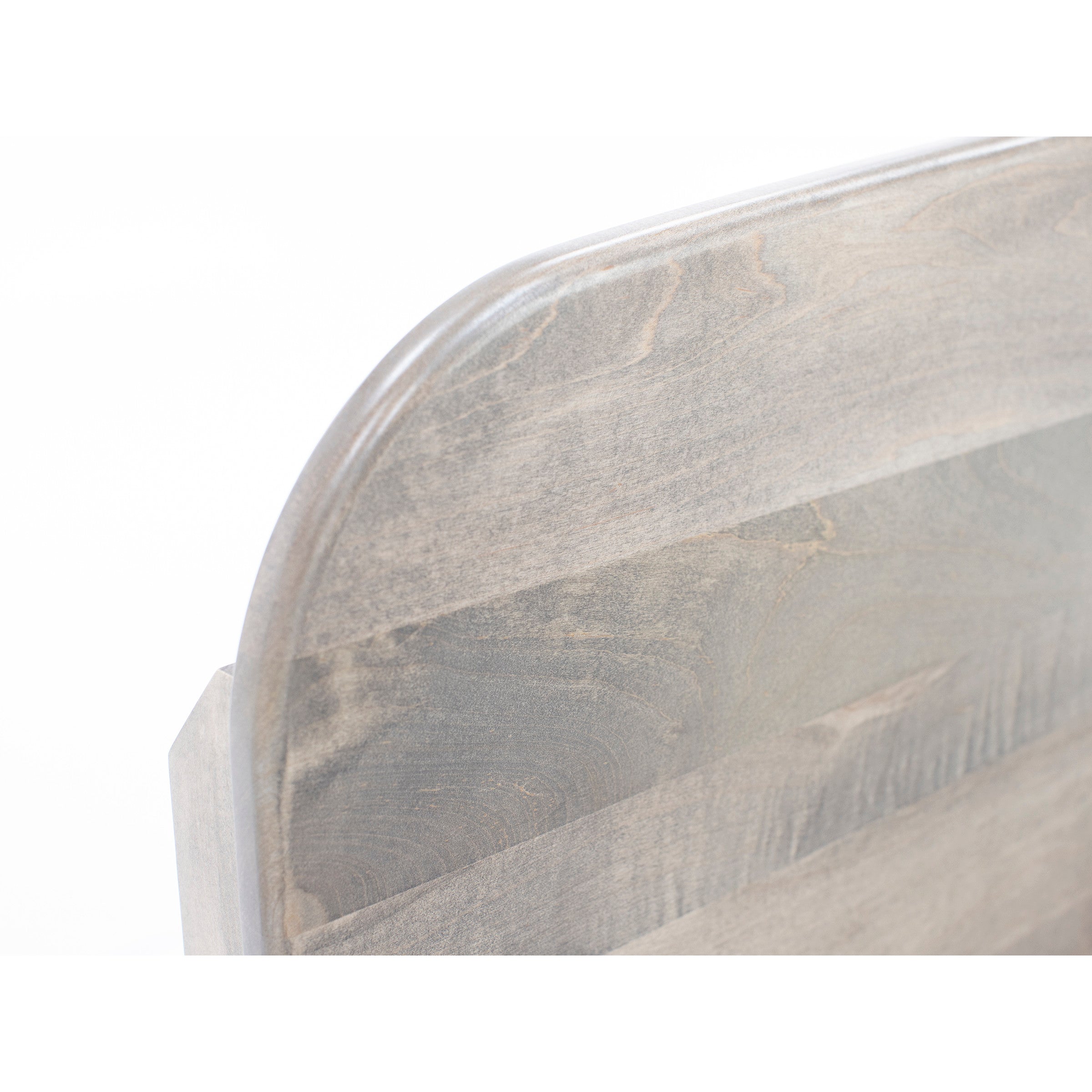 Close-up of a gray wooden headboard with rounded corner.