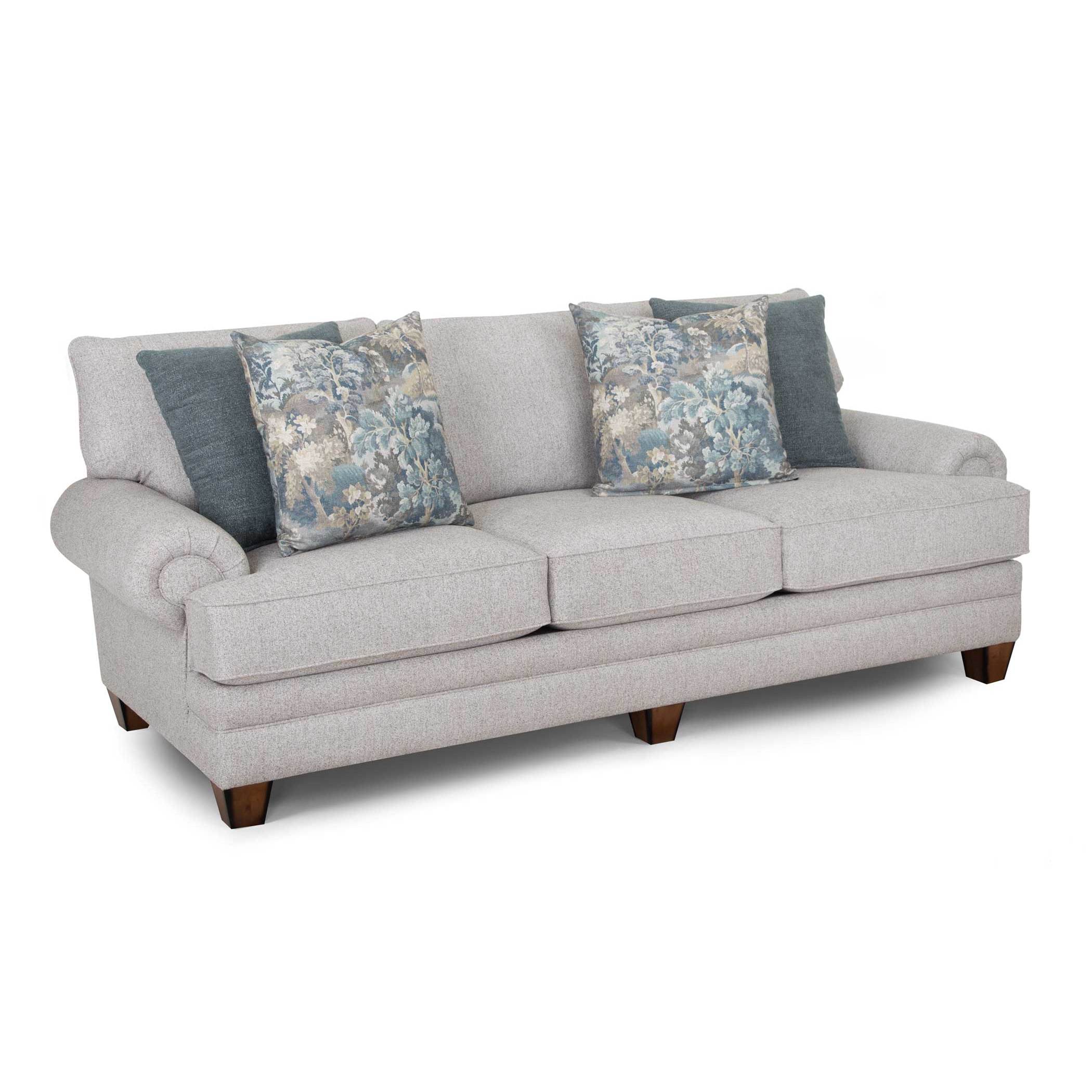 Light gray sofa with rolled arms and blue decorative pillows.