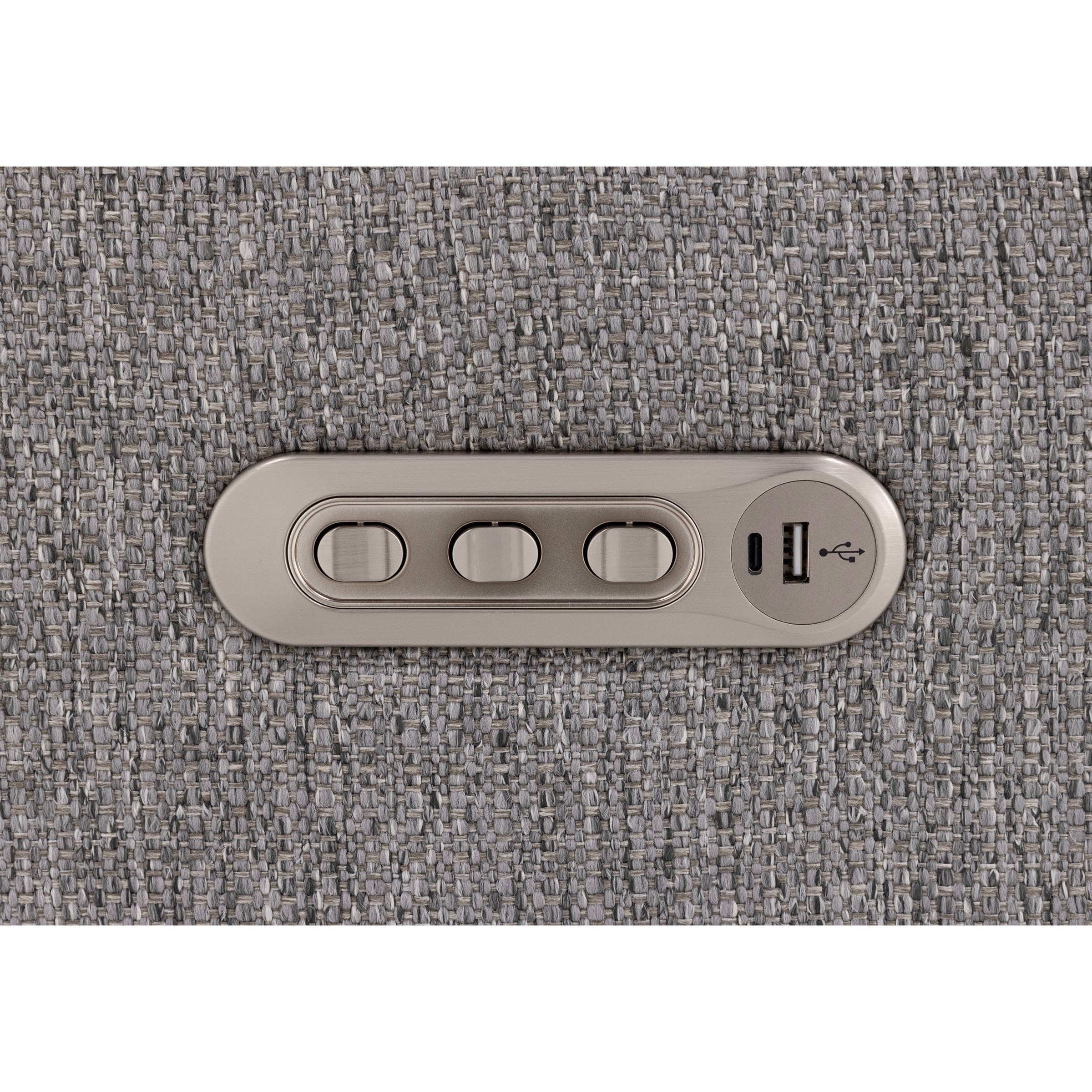 Silver control panel with three buttons and USB ports on gray fabric.