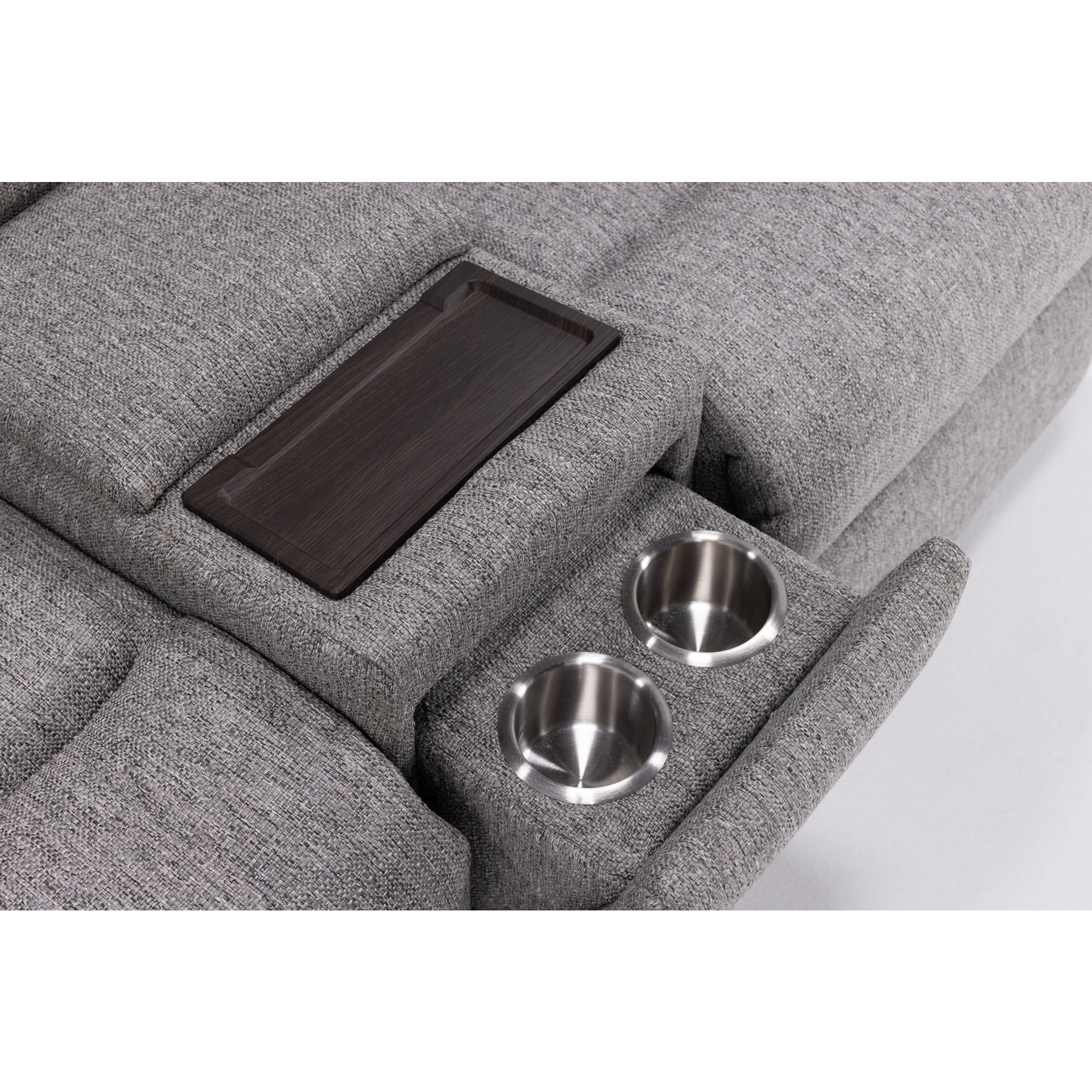 Close-up of gray sofa armrest with two stainless steel cup holders and a dark wooden tray.