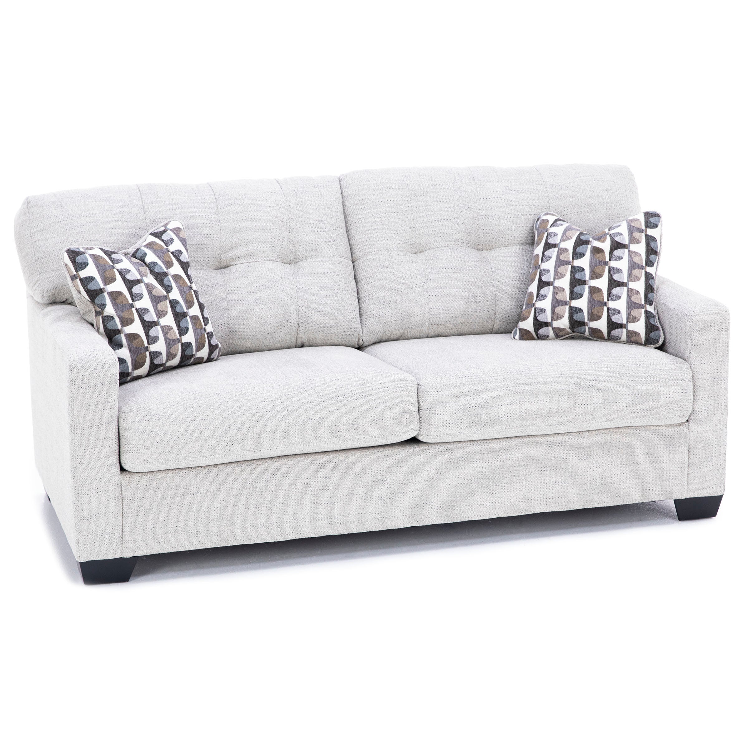 Light gray sofa with tufted back and two patterned accent pillows.