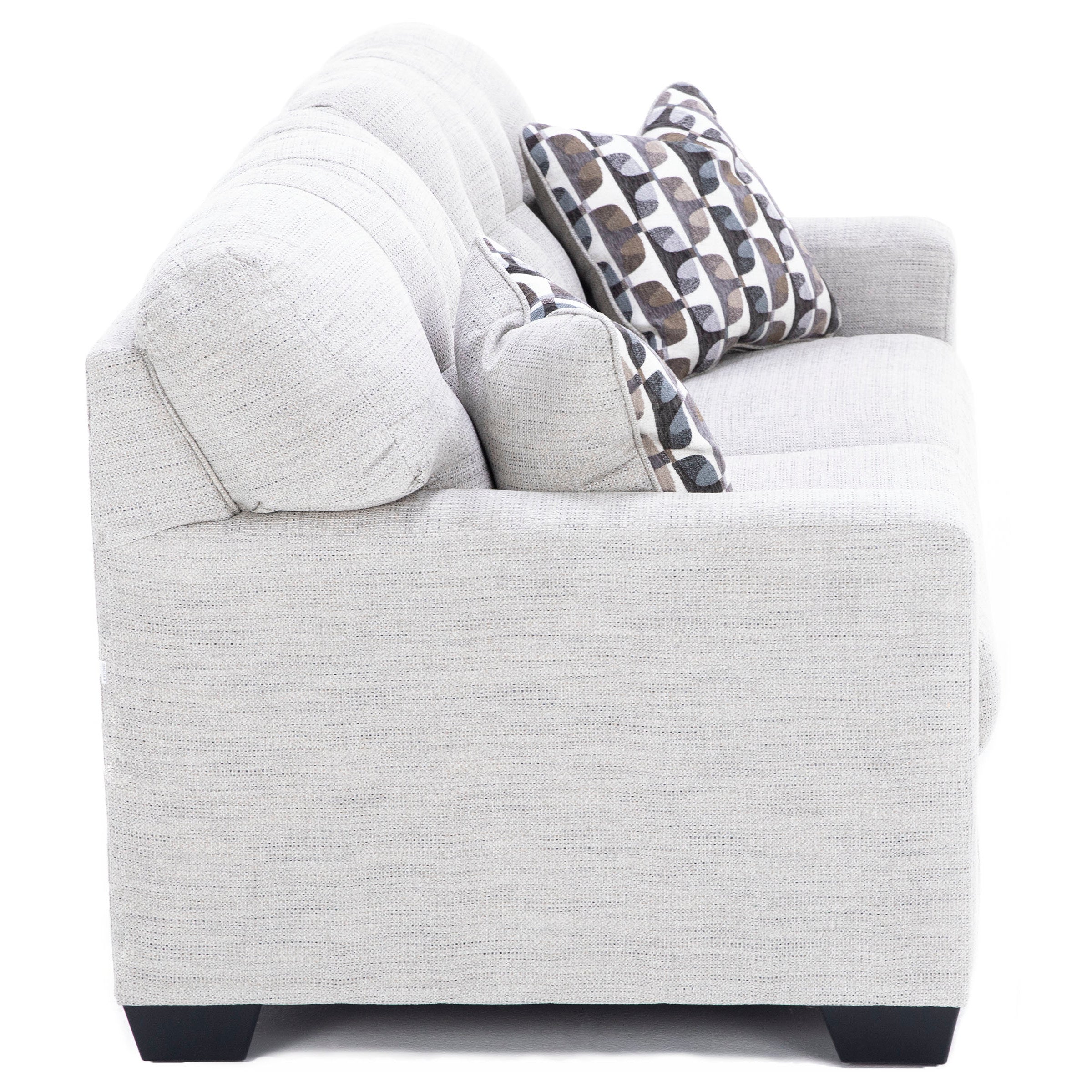 Side view of a light gray upholstered sofa with geometric patterned pillows.