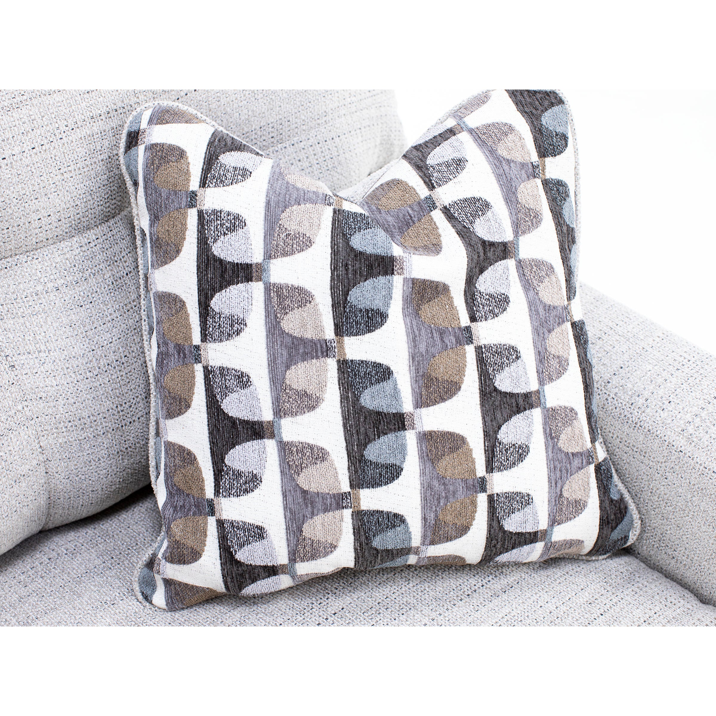 Geometric patterned pillow on a light gray upholstered sofa.