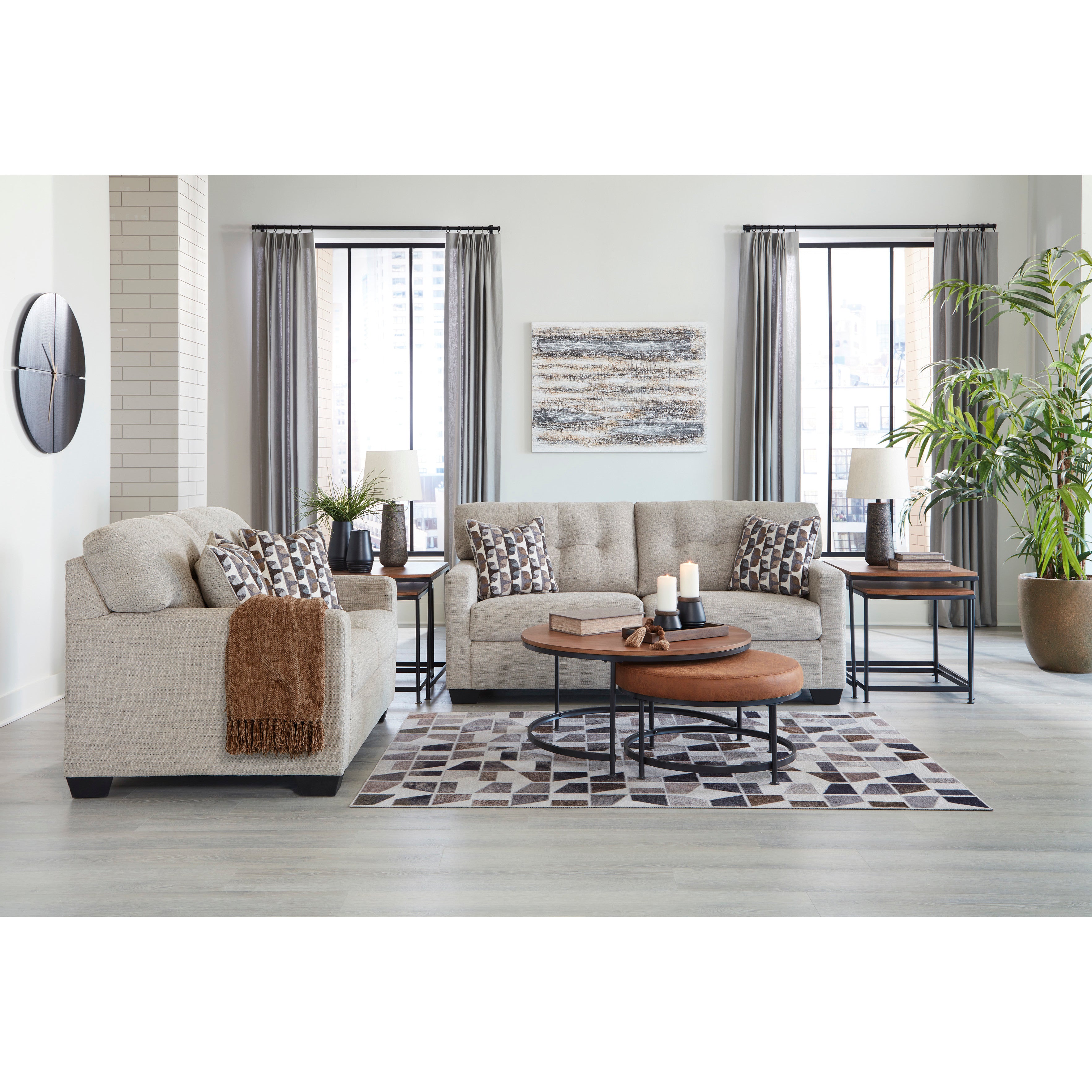 Modern living room with beige sofas, geometric pillows, and wooden tables on a patterned rug.