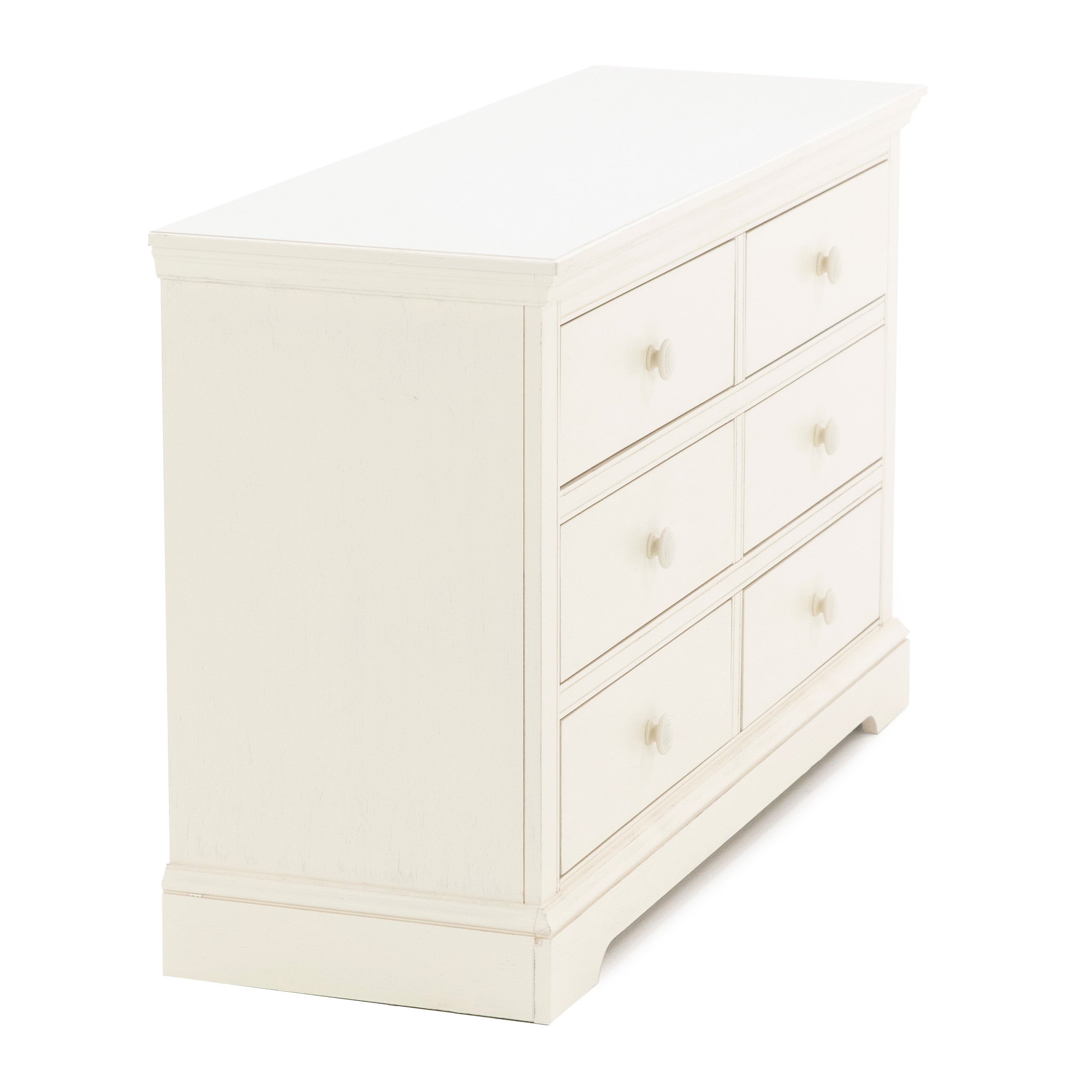 Off-white six-drawer dresser with round knobs, angled view.