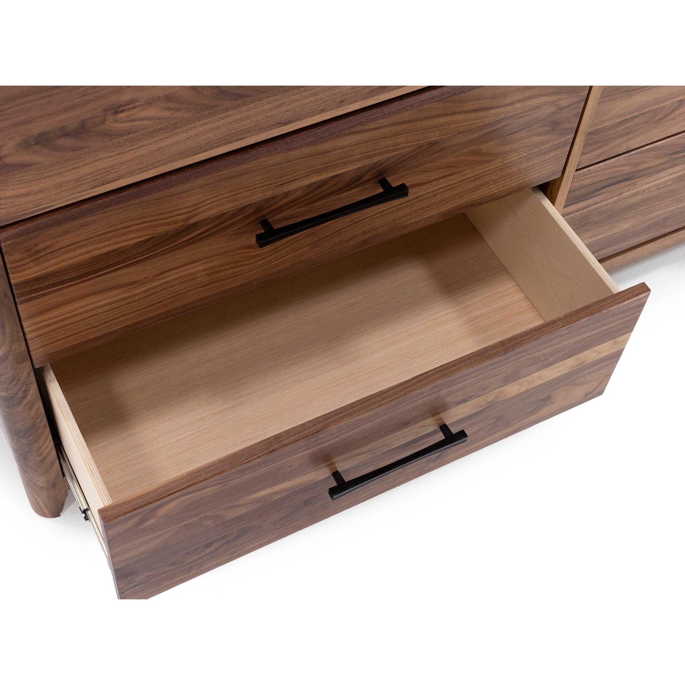 Open wooden drawer with metal handle in a dresser.