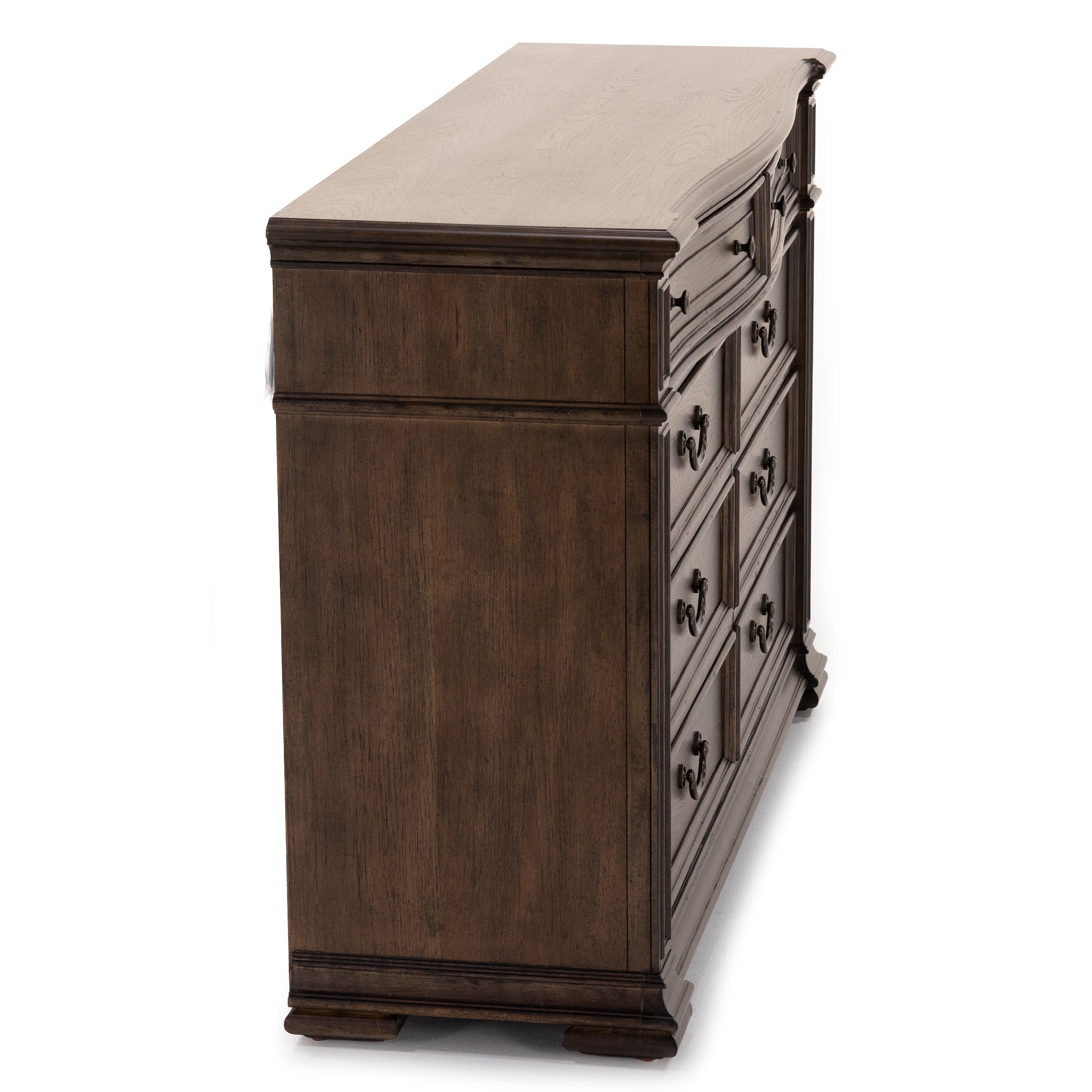 Side view of a dark wood dresser with ornate drawer handles.