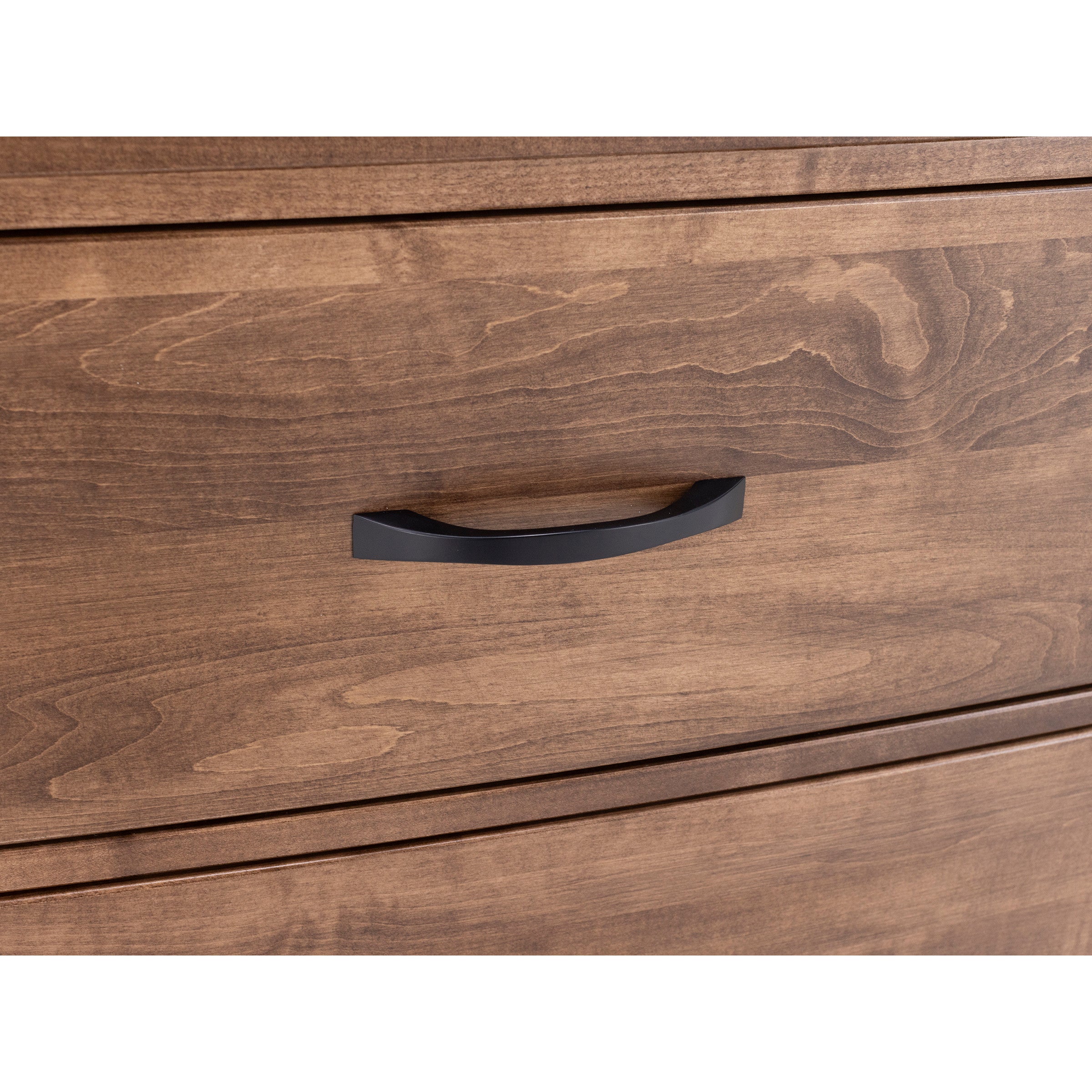 Close-up of a wood dresser drawer with a black metal handle.