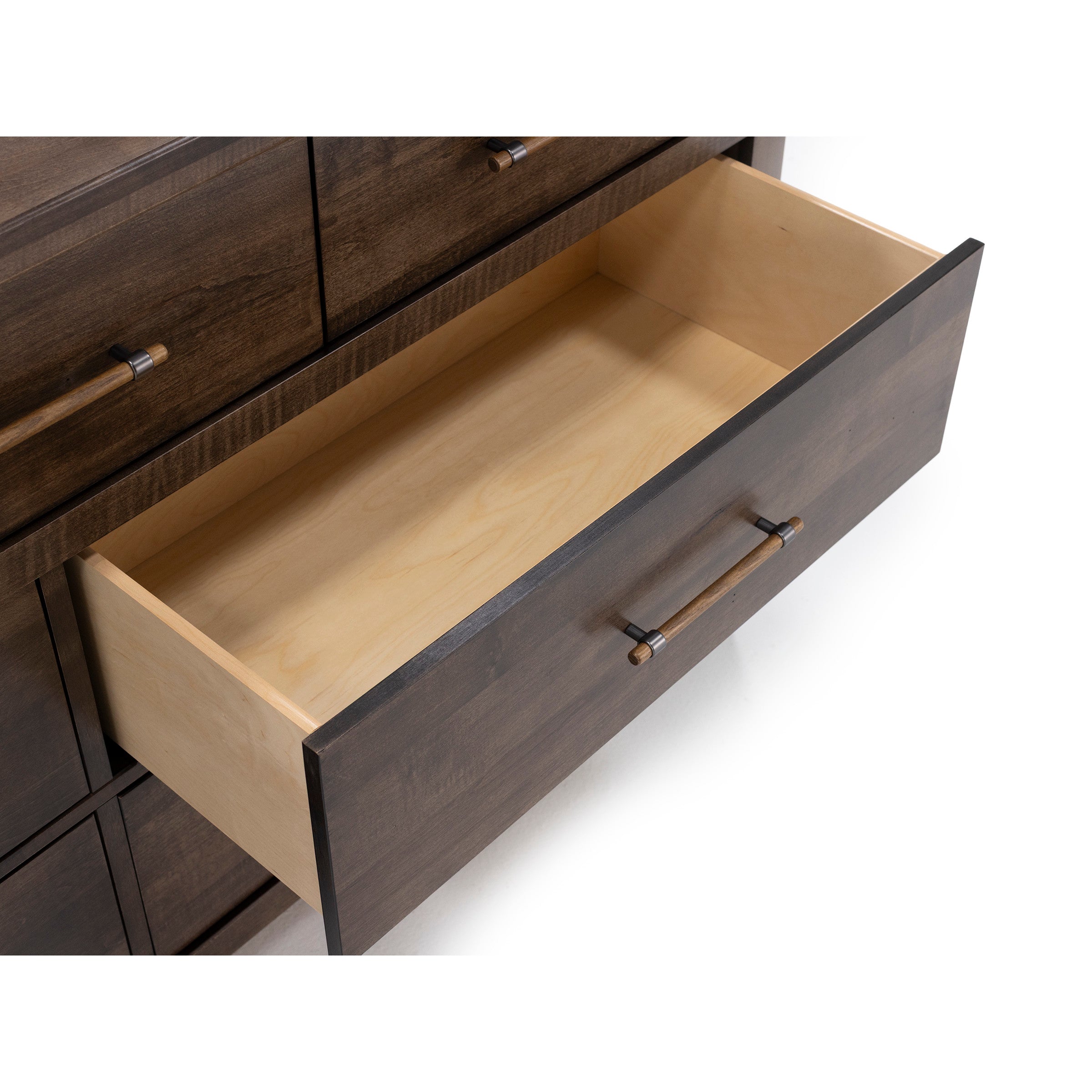 Open drawer in a dark wood dresser with metal handles, viewed from above.