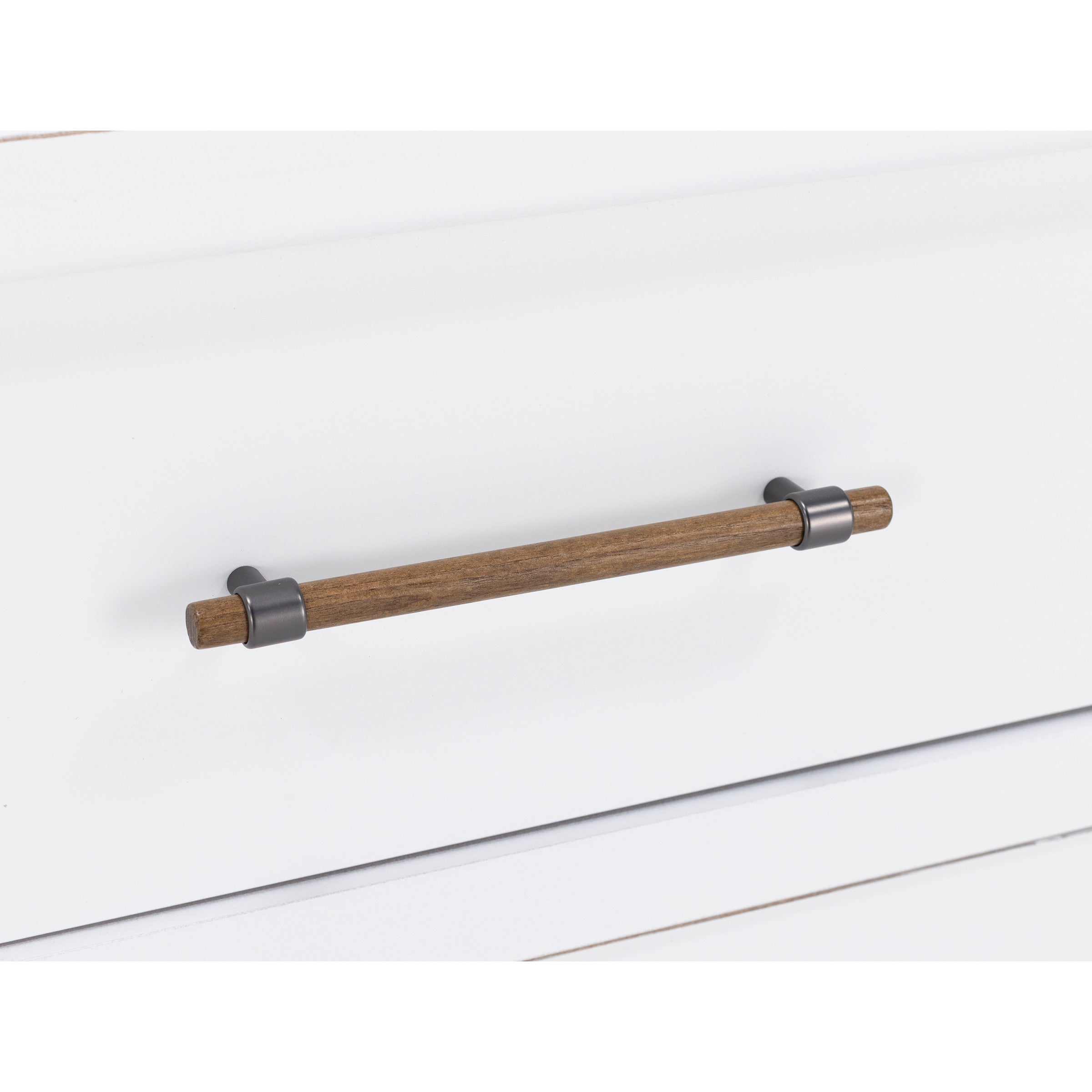 Close-up of a wooden and metal drawer handle on a white drawer.