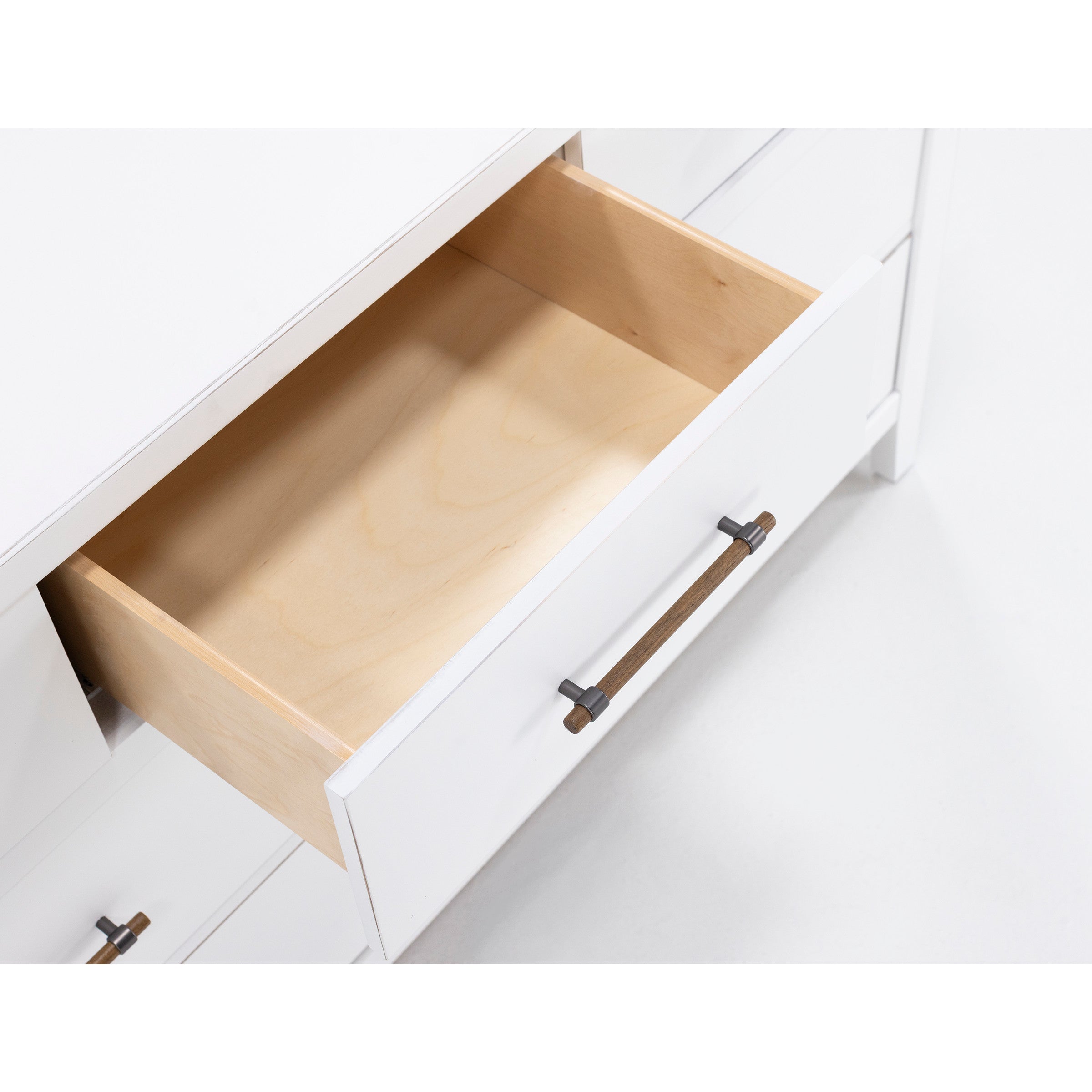 Open white dresser drawer with wood handle, empty interior