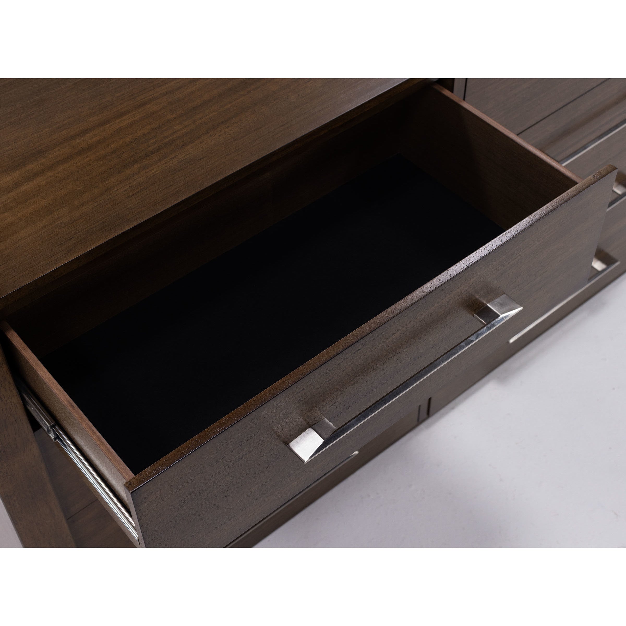 Open empty wooden drawer with silver handle
