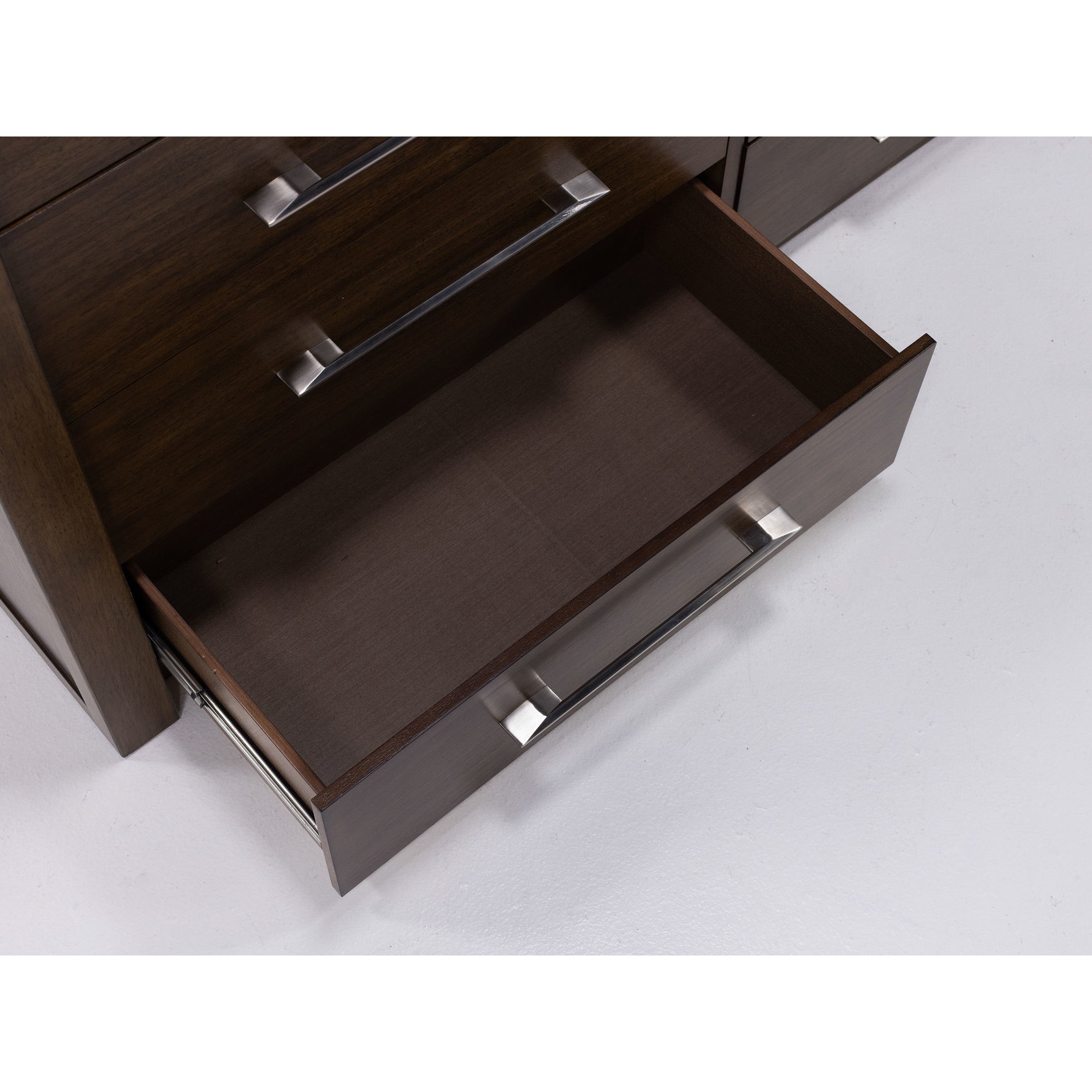 Open wooden drawer with metal handle, viewed from above.