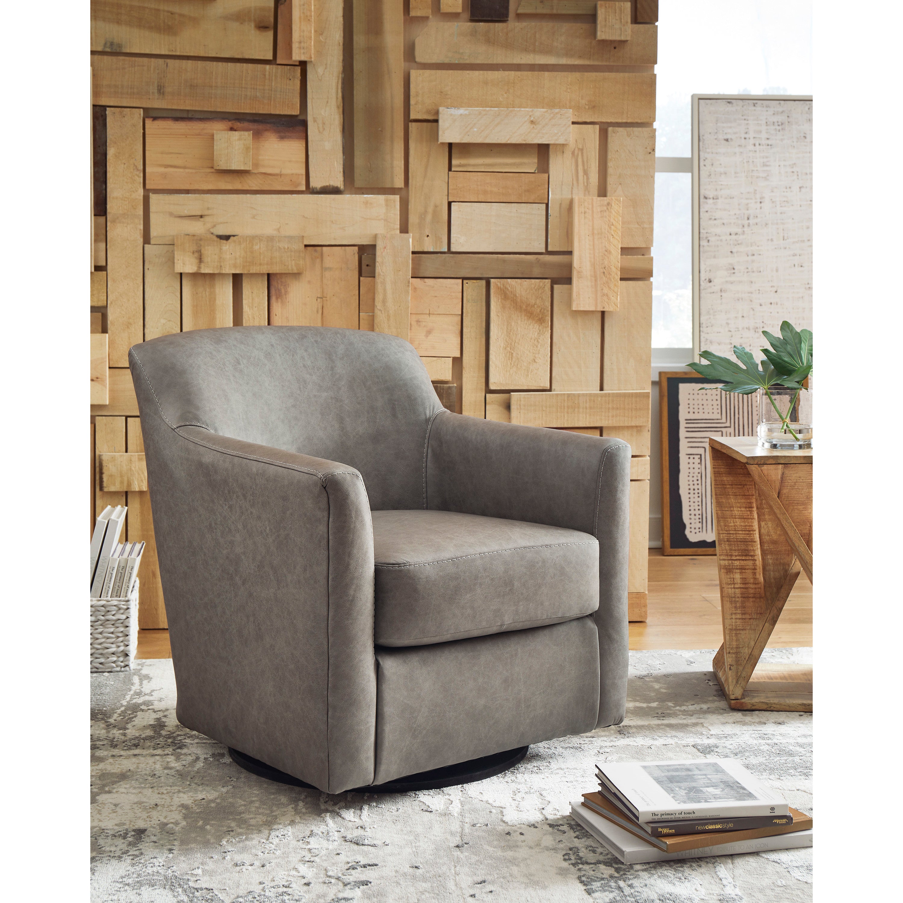 Gray swivel accent chair in modern living room with wood block panel wall.