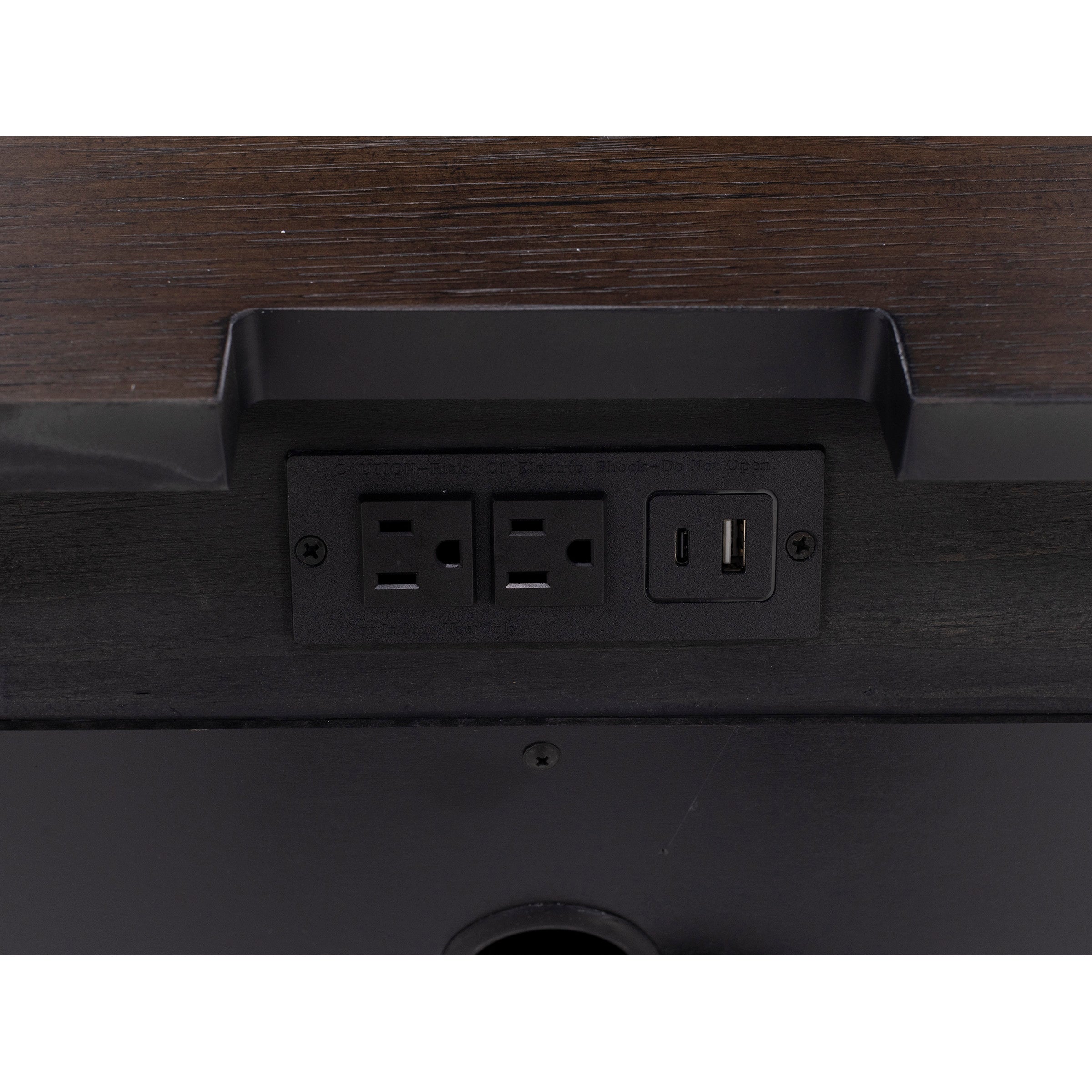 Close-up of built-in power outlets and USB ports on a dark wood furniture surface.