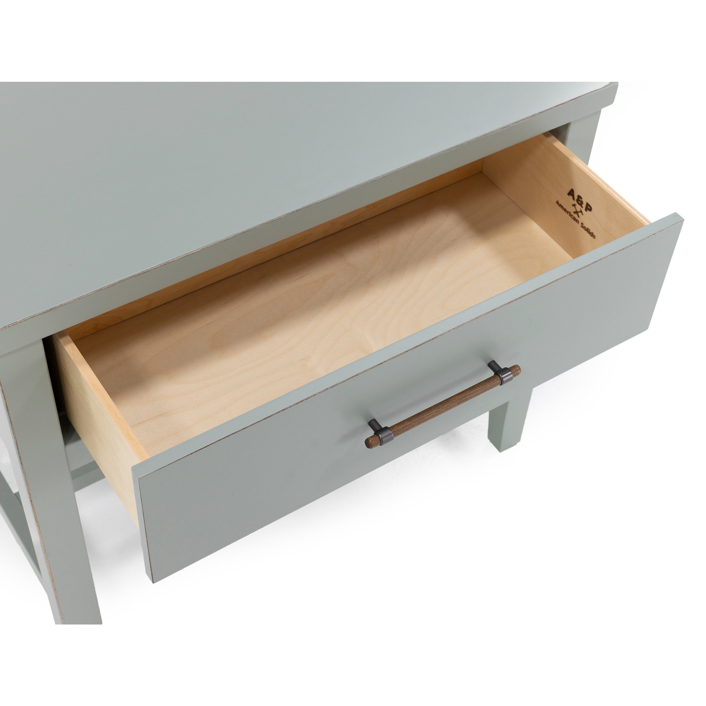 Open drawer of a light gray wooden desk with a wooden handle, viewed from above.