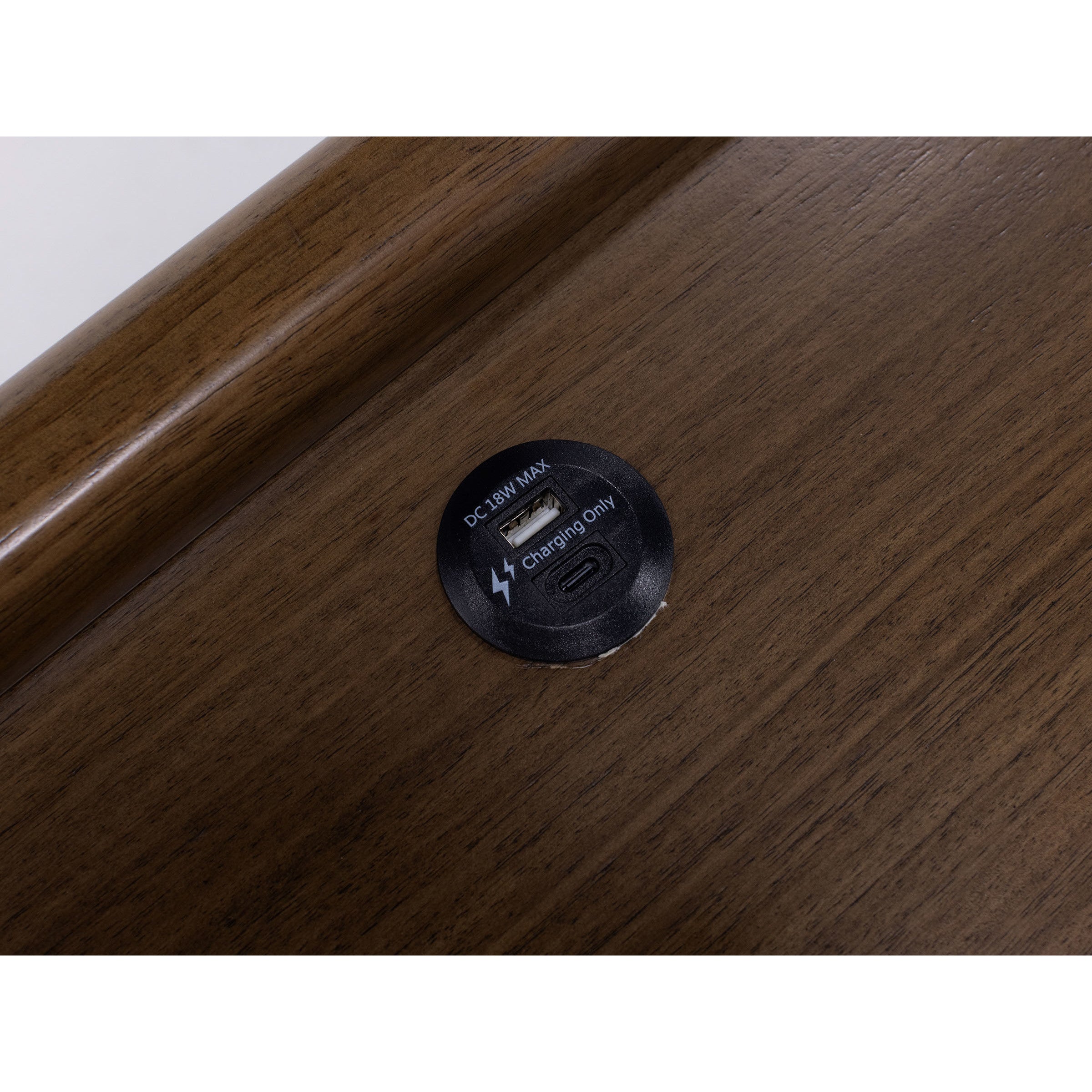 Circular USB and USB-C charging port on a wood surface.