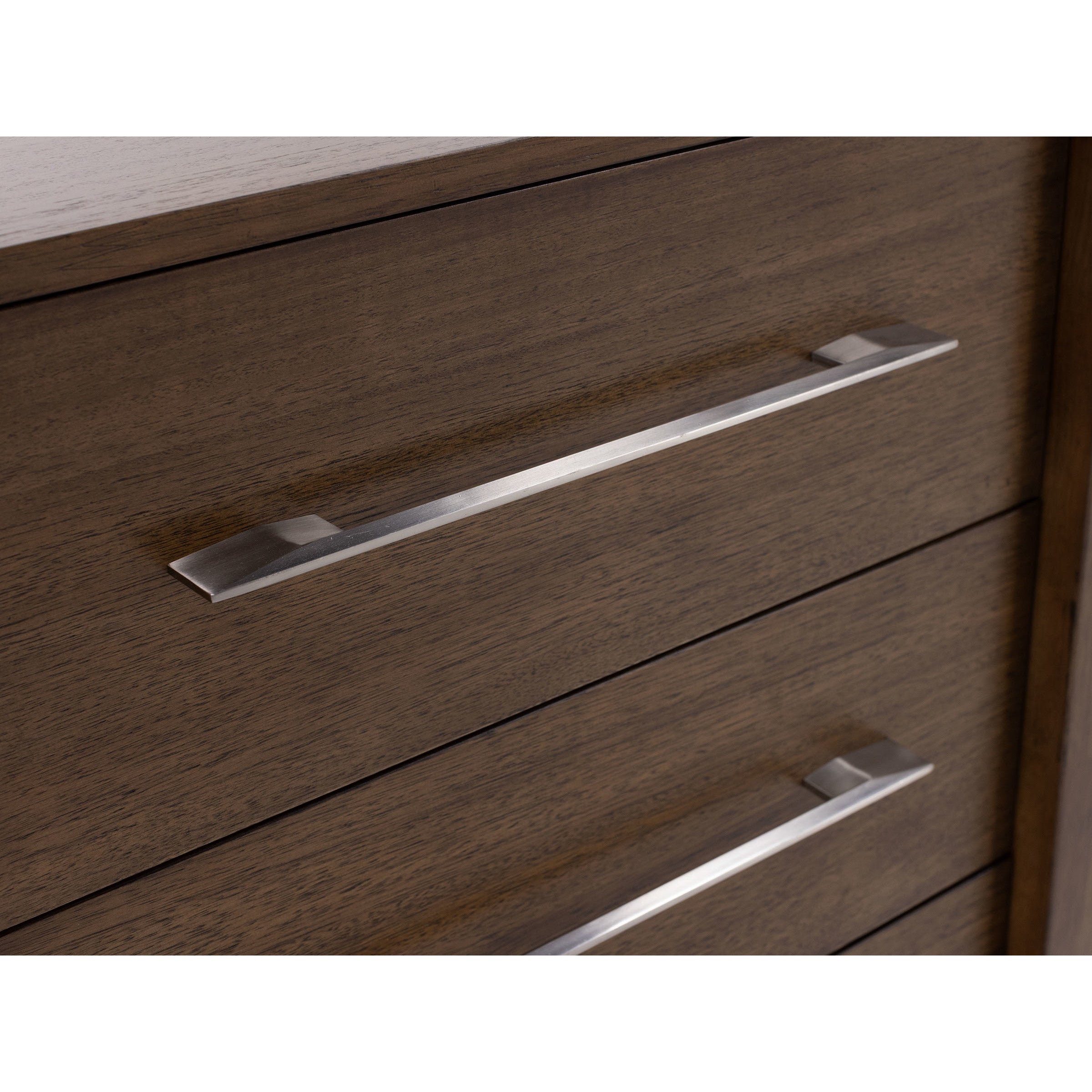 Close-up of modern silver drawer handles on dark wood dresser.