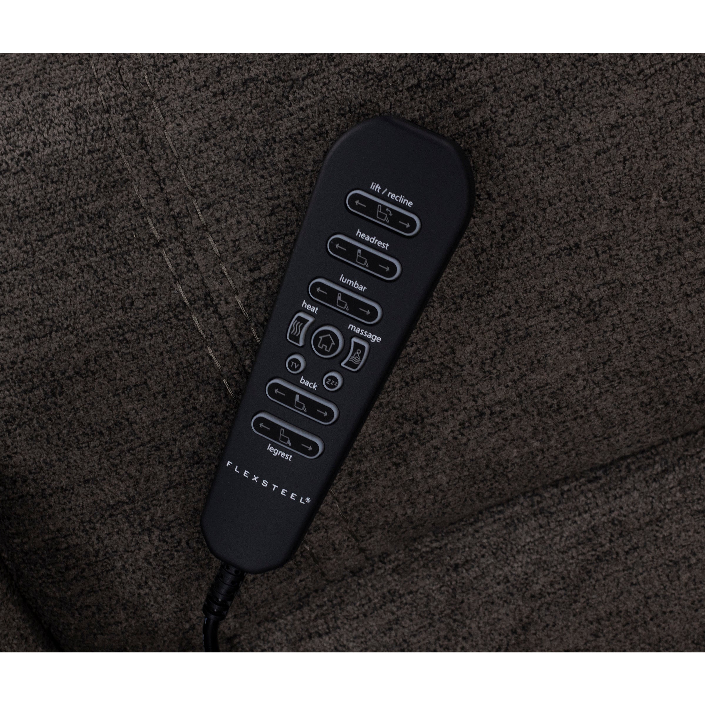 Remote control for reclining furniture on a brown fabric surface.